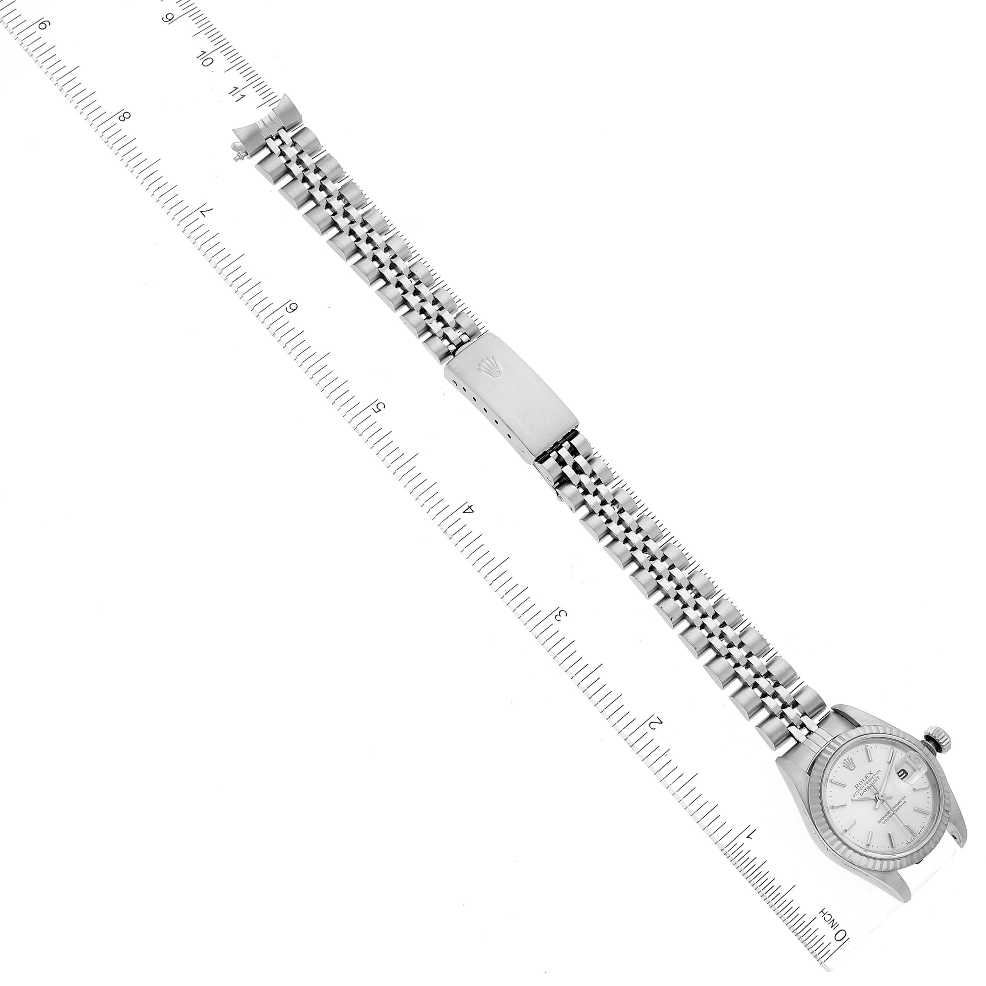 This image shows a Rolex Datejust 79174 Women's Stainless Steel Silver Dial 79174 Women's Stainless Steel Silver Dial watch laid flat, displaying its face, bracelet, and clasp with a ruler for scale.