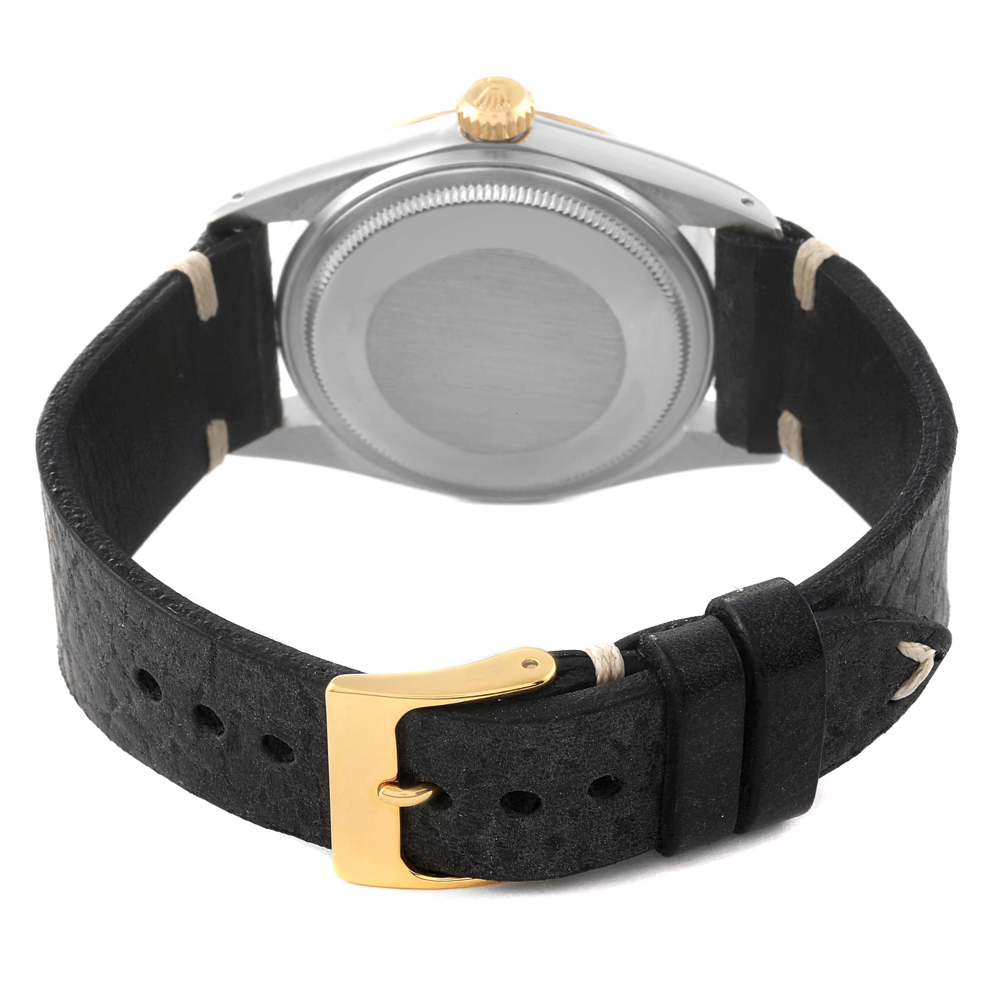 The image shows the back view of a Rolex Datejust 16013 Men's Steel and Gold (two tone) Black Dial 16013 Men's Steel and Gold (two tone) Black Dial watch with a black leather strap and a gold buckle.