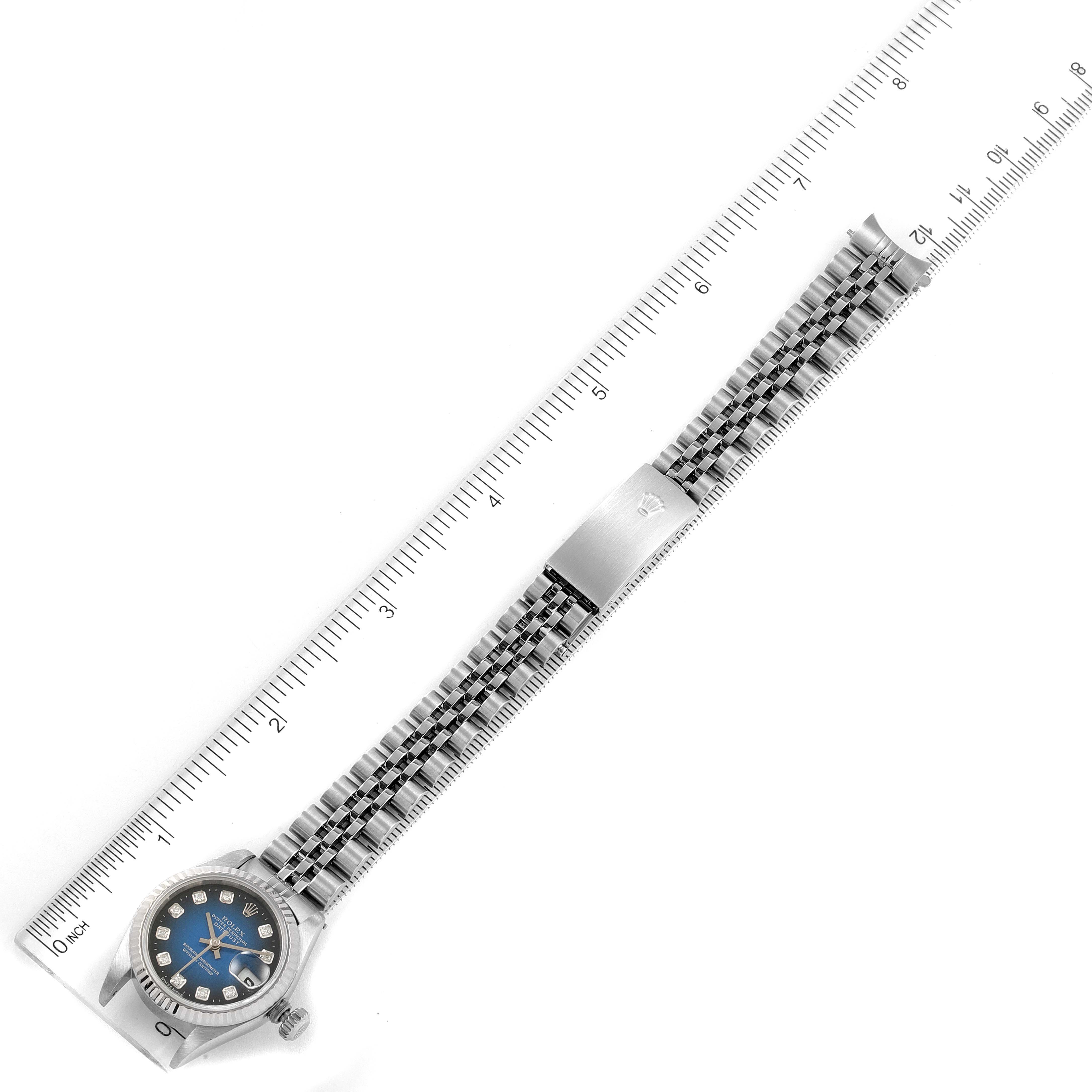 This image shows a top-down view of a Rolex Datejust 79174 Women's Stainless Steel Blue Dial 79174 Women's Stainless Steel Blue Dial watch with a metal bracelet and a ruler for scale.