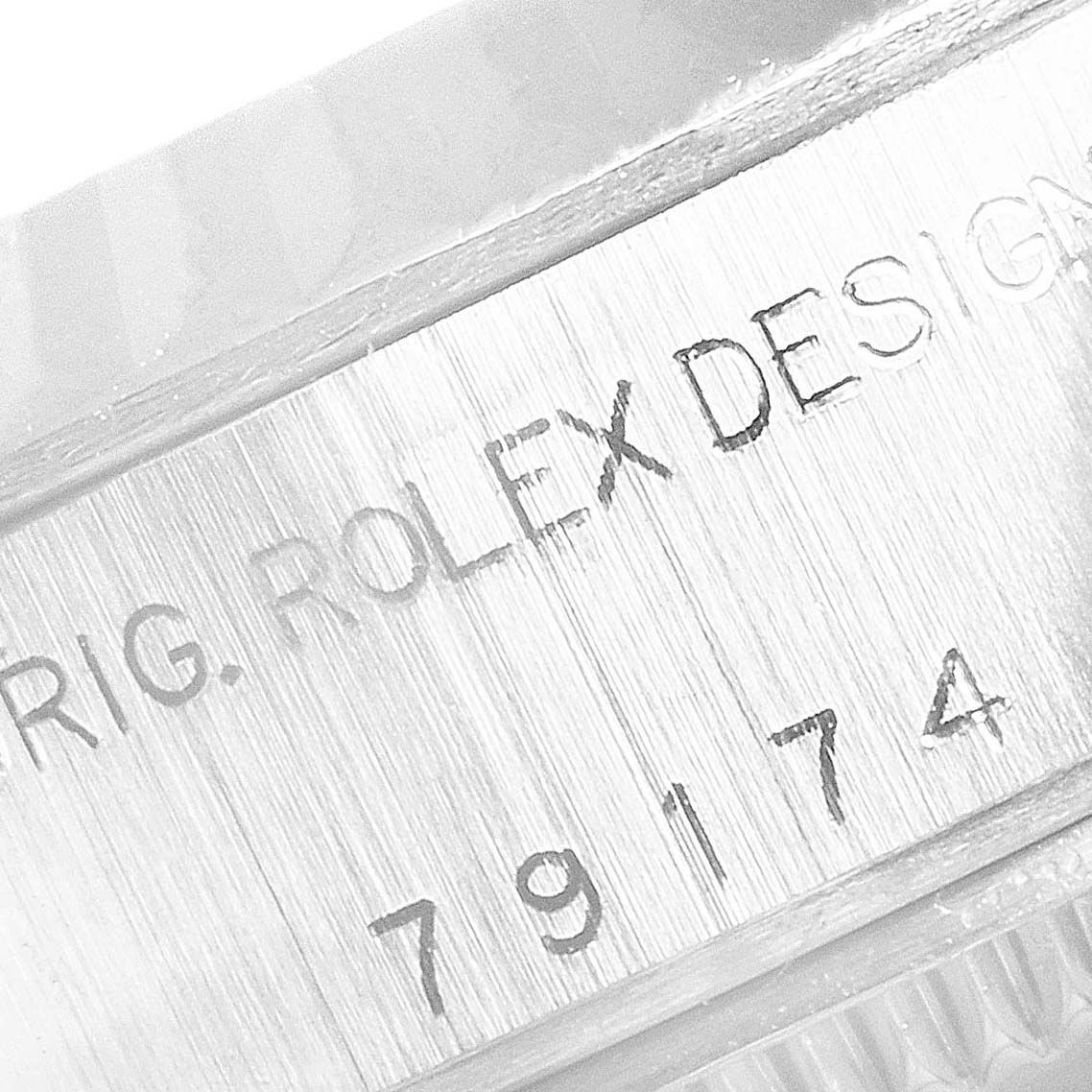 This image shows a close-up of the case back of a Rolex Datejust 79174 Women's Stainless Steel Blue Dial 79174 Women's Stainless Steel Blue Dial, focusing on the "ORIG. ROLEX DESIGN" and model number 79174.