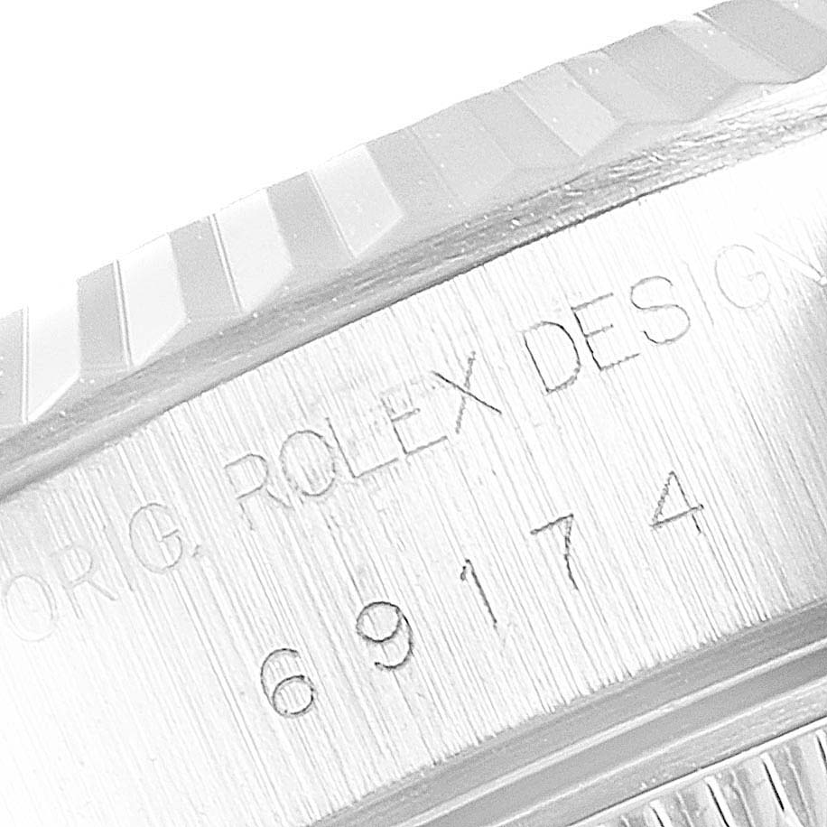 This image shows a close-up of the Rolex Datejust 69174 Women
s Stainless Steel Silver Dial 69174 Women
s Stainless Steel Silver Dial model
s bezel and serial number engraved on the case.