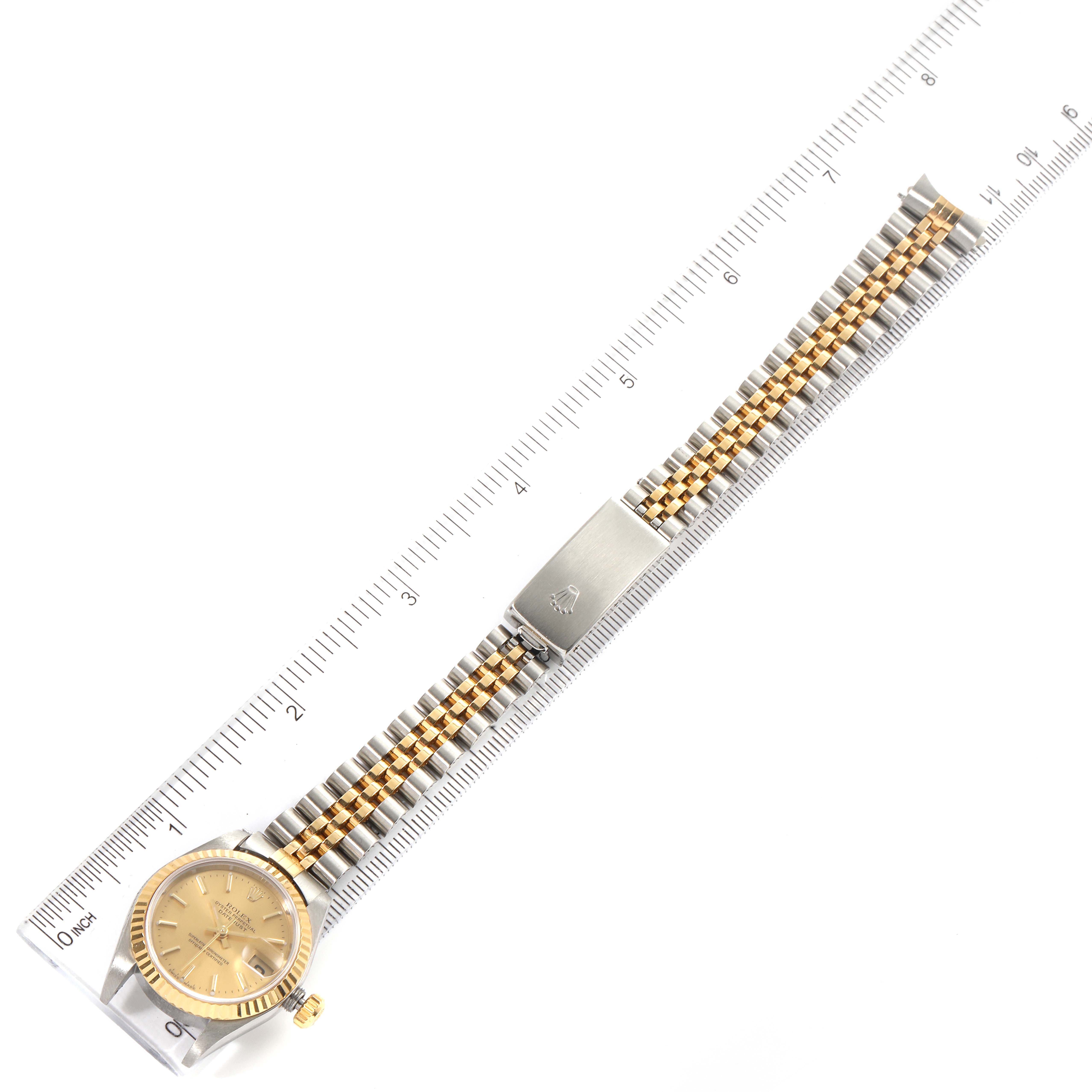 The image shows a top-down view of a Rolex Datejust 79173 Women's Steel and Gold (two tone) Champagne Dial 79173 Women's Steel and Gold (two tone) Champagne Dial watch with a measuring ruler beneath it.
