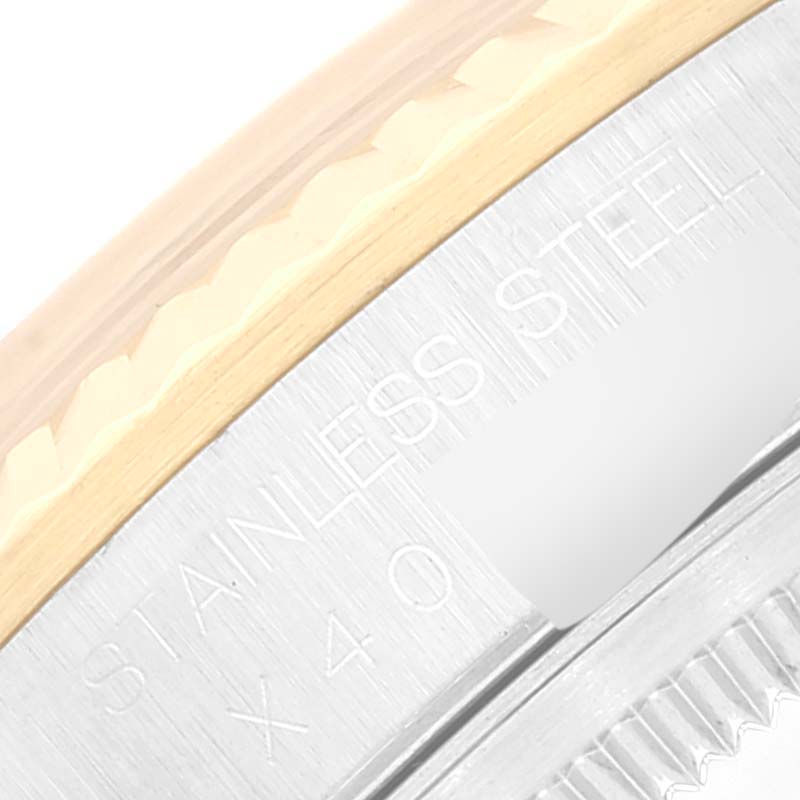 This close-up image shows the edge of a Rolex Datejust 16233 Men's Steel and Gold (two tone) Silver Dial 16233 Men's Steel and Gold (two tone) Silver Dial watch, highlighting its stainless steel bezel and markings.