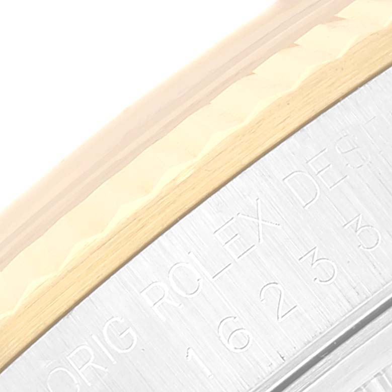 The image shows a close-up of the bezel and case edge of the Rolex Datejust 16233 Men's Steel and Gold (two tone) Silver Dial 16233 Men's Steel and Gold (two tone) Silver Dial watch, highlighting engraved text.