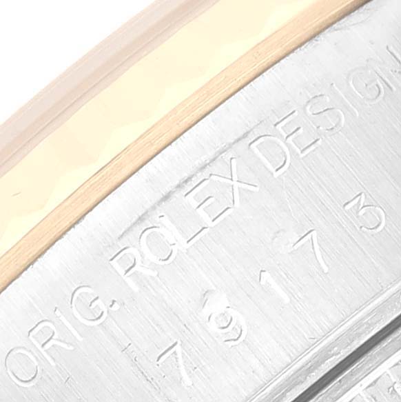 This is an angled close-up of the side engraving on a Rolex Datejust 79173G Women's Steel and Gold (two tone) Grey Dial 79173G Women's Steel and Gold (two tone) Grey Dial watch.