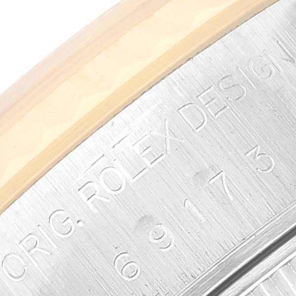 This image shows a close-up of the engraved detailing on the side of a Rolex Datejust 69173 Women's Steel and Gold (two tone) White Dial 69173 Women's Steel and Gold (two tone) White Dial watch.