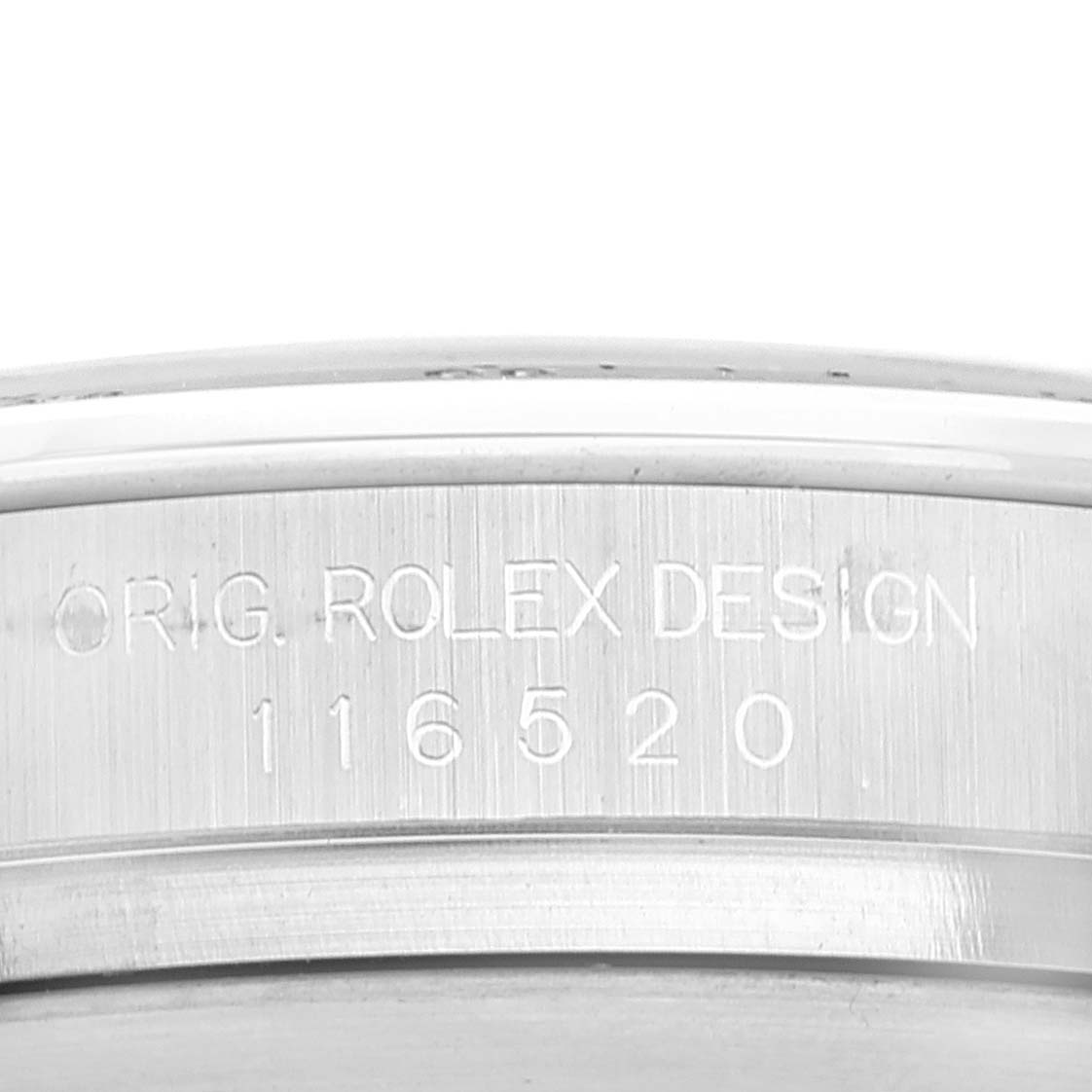 This close-up image shows the engraved serial number and "ORIG. ROLEX DESIGN" on the case of a Rolex Daytona 116520 Men's Stainless Steel Black Dial 116520 Men's Stainless Steel Black Dial watch.