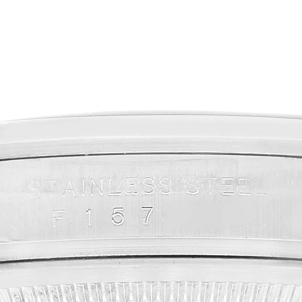This image shows a close-up of the side engraving on the case of a Rolex Explorer 114270 Men
s Stainless Steel Black Dial 114270 Men
s Stainless Steel Black Dial watch, displaying "STAINLESS STEEL" and "F 157".