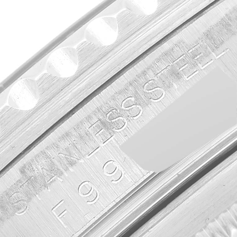 This image shows a macro shot of the side of a Rolex GMT-Master 16710 Men's Stainless Steel Black Dial 16710 Men's Stainless Steel Black Dial watch, focusing on the engraved "STAINLESS STEEL" text.