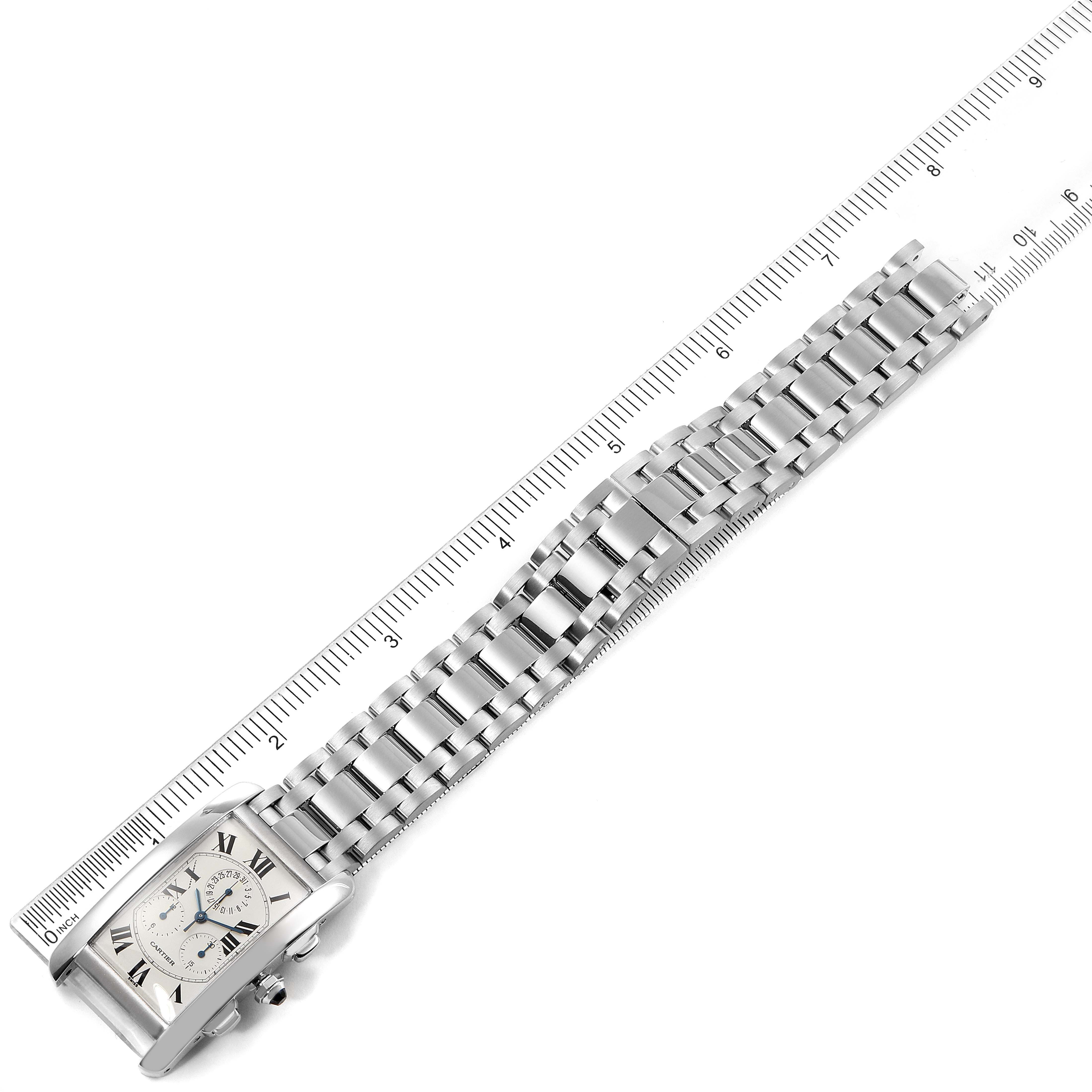 This image shows a Cartier Tank Americaine W26033L1 Men's White Gold Silver Dial W26033L1 Men's White Gold Silver Dial watch with its metal bracelet next to a ruler for scale.