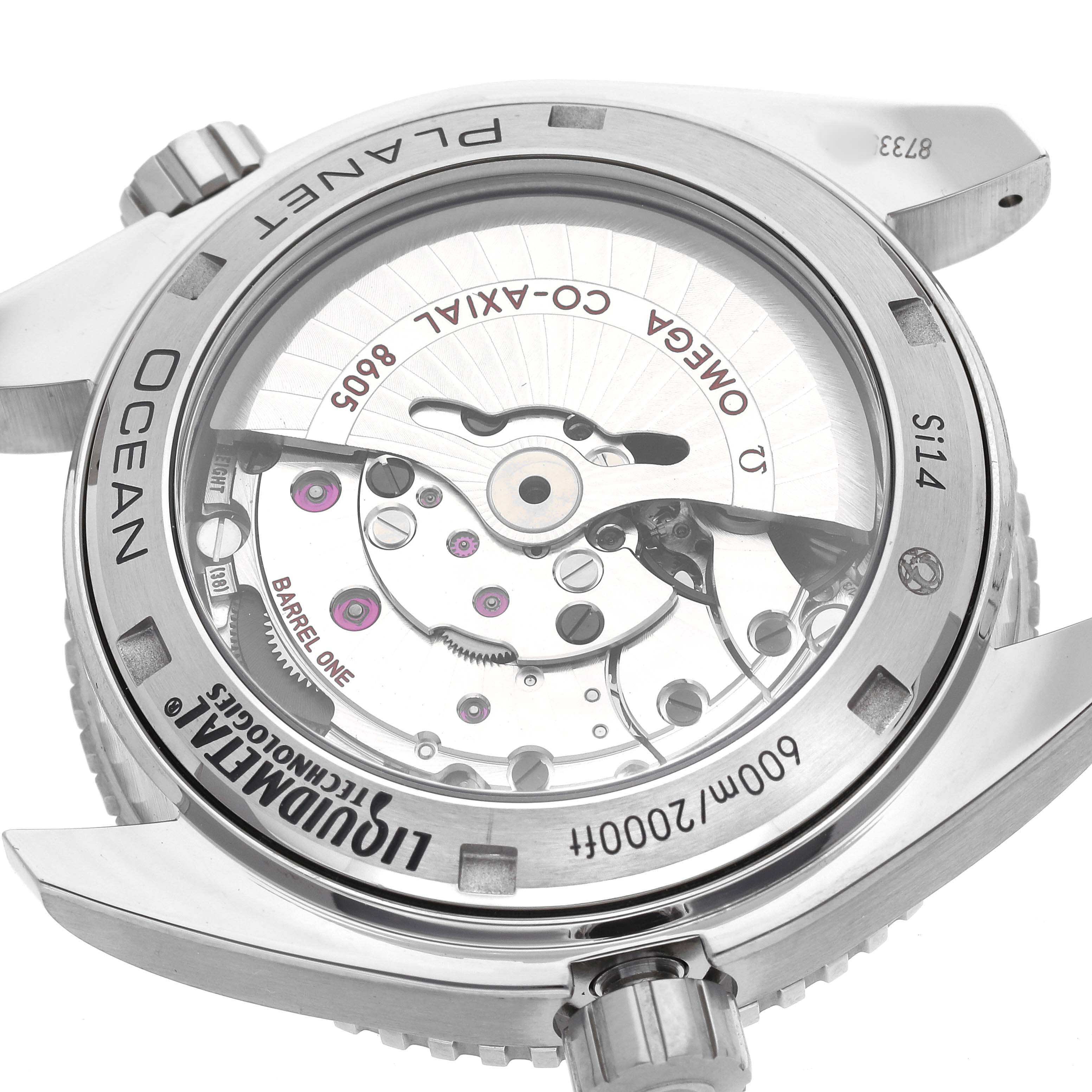 The image shows the back view of the Omega Seamaster 232.92.44.22.03.001 Men's Titanium Blue Dial watch, highlighting its movement and engravings.