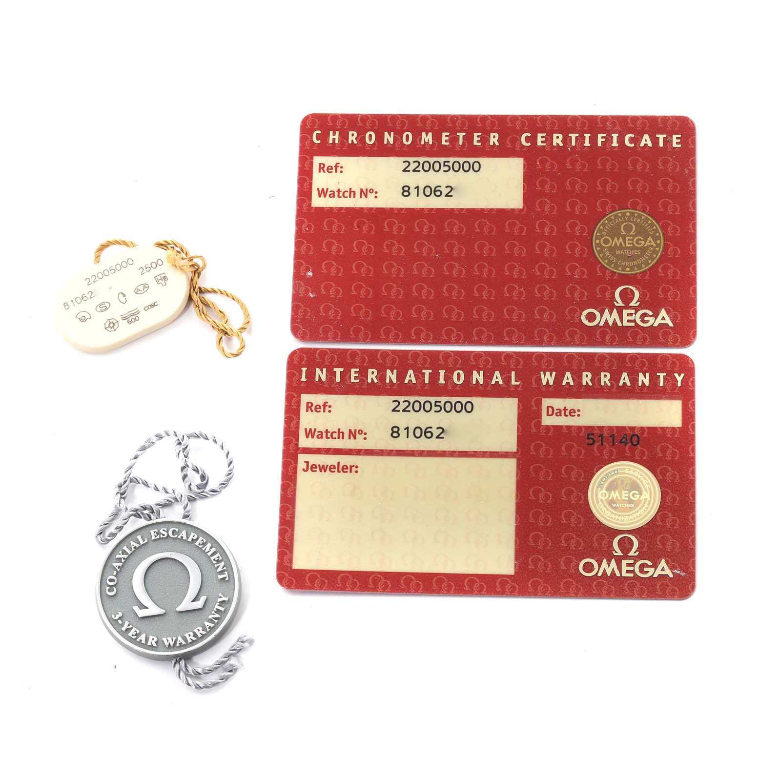 This image shows the certification and warranty cards, along with a tag and medallion for the Omega Planet Ocean 2200.50.00 Men
s Stainless Steel Black Dial 2200.50.00 Men
s Stainless Steel Black Dial model watch, from a top-down angle.