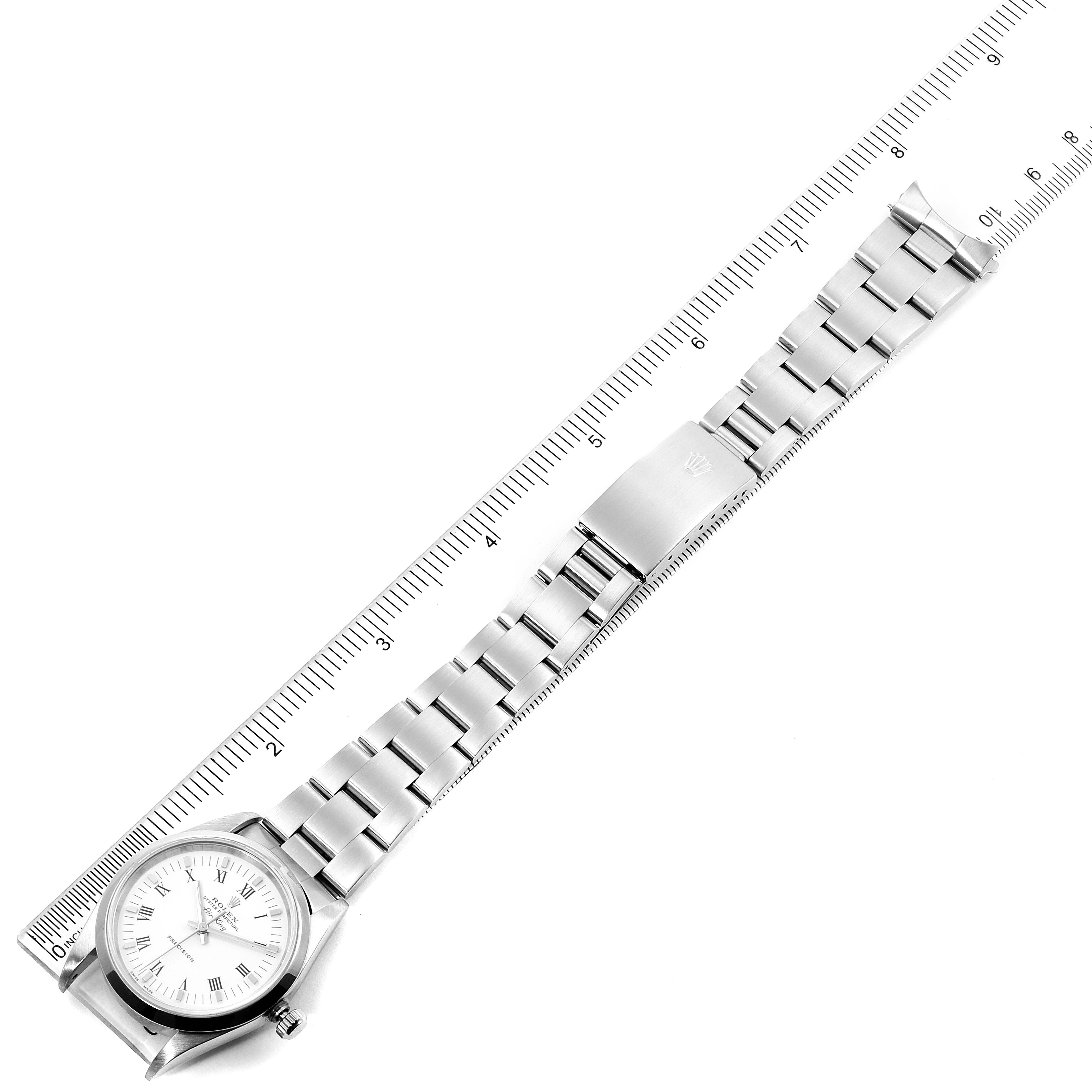 The Rolex Air-King 14010M Men's Stainless Steel White Dial 14010M Men's Stainless Steel White Dial watch is shown laid flat next to a ruler, displaying the watch face and full metal bracelet.