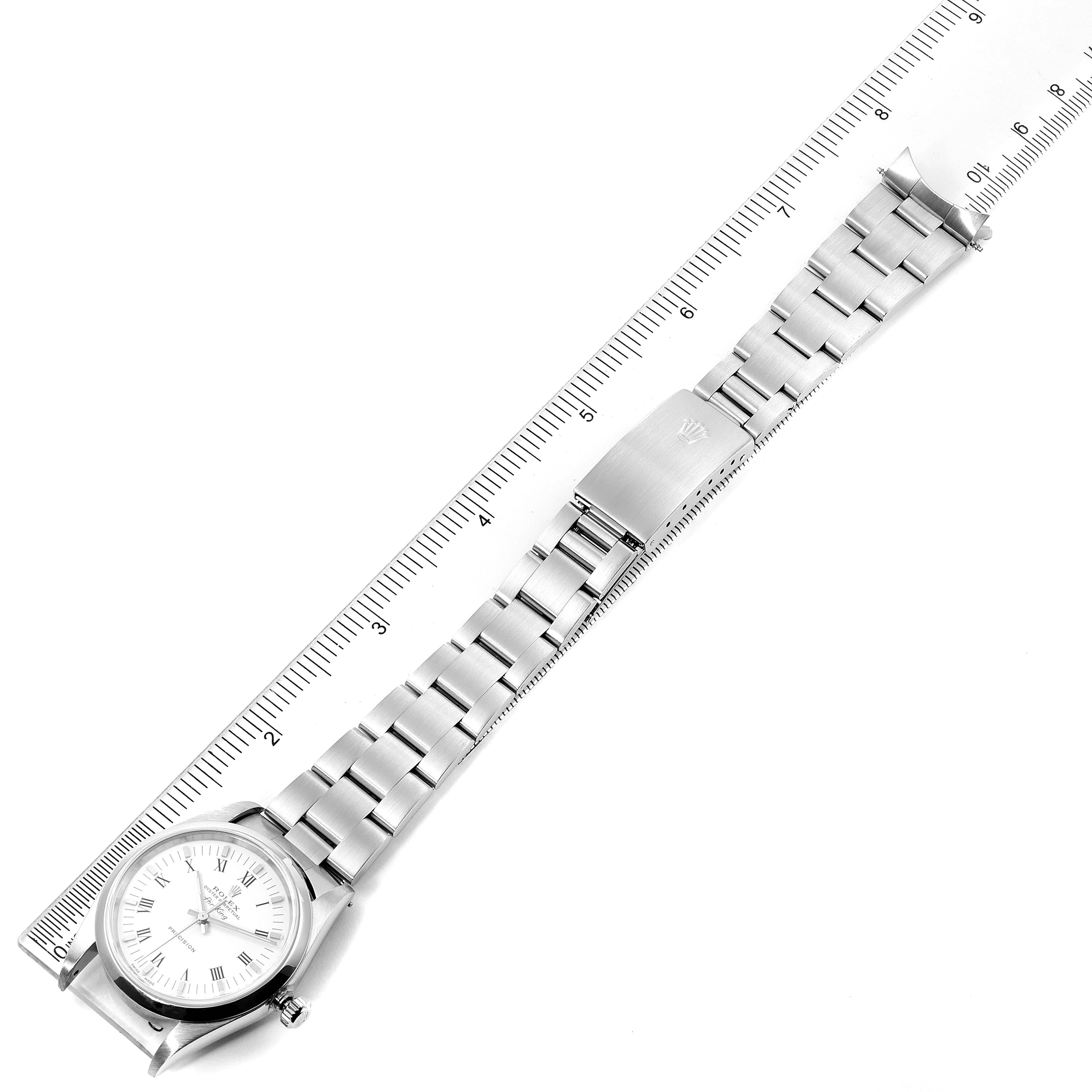 The image shows a flat, top-down view of the Rolex Air-King 14000 Men's Stainless Steel White Dial 14000 Men's Stainless Steel White Dial watch and its metallic strap, positioned alongside a ruler.