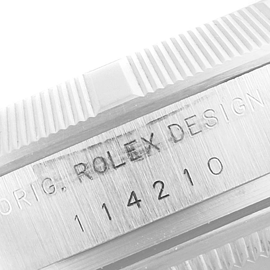 The image shows a close-up of the bezel and case with engravings on a Rolex Air-King 114210 Men's Stainless Steel Silver Dial 114210 Men's Stainless Steel Silver Dial watch.