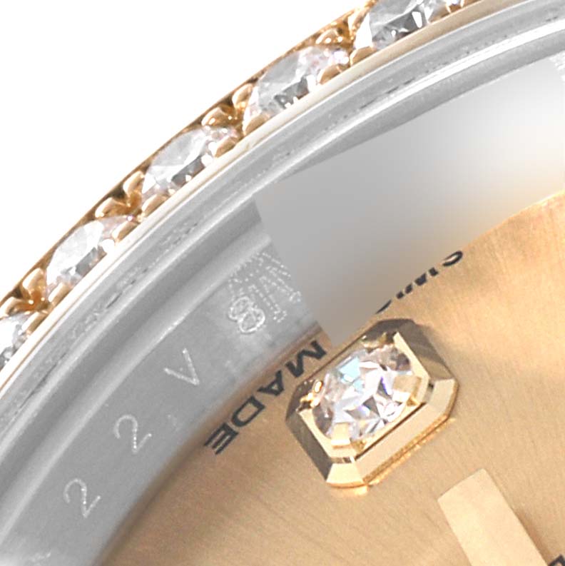 This close-up of a Rolex Datejust 179383 Women's Steel and Gold (two tone) Champagne Dial 179383 Women's Steel and Gold (two tone) Champagne Dial watch shows the bezel with diamonds and part of the dial with a diamond hour marker.