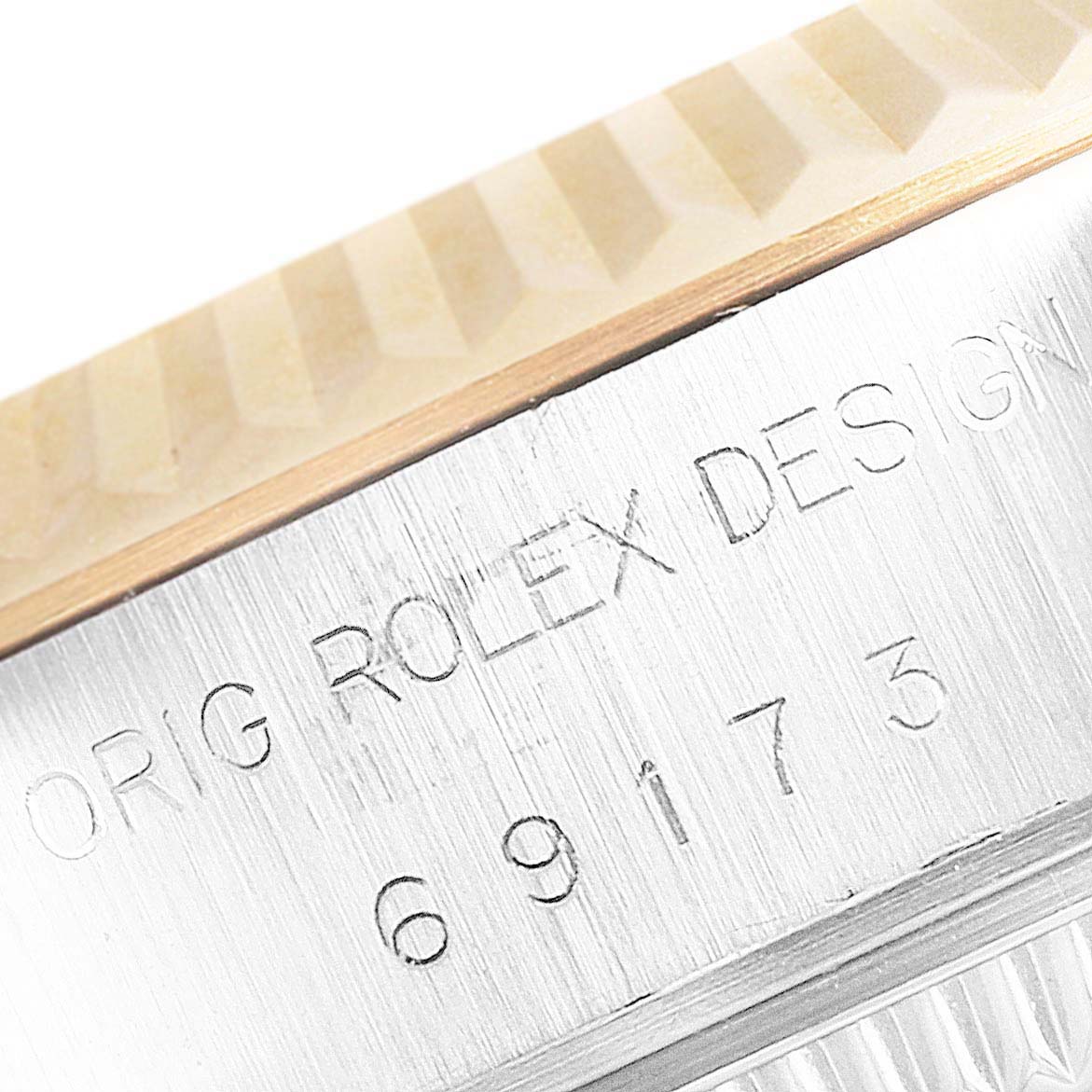 This image shows a close-up of the side of a Rolex Datejust 69173 Men's Steel and Gold (two tone) Champagne Dial 69173 Men's Steel and Gold (two tone) Champagne Dial watch, highlighting the fluted bezel and engraved serial number.