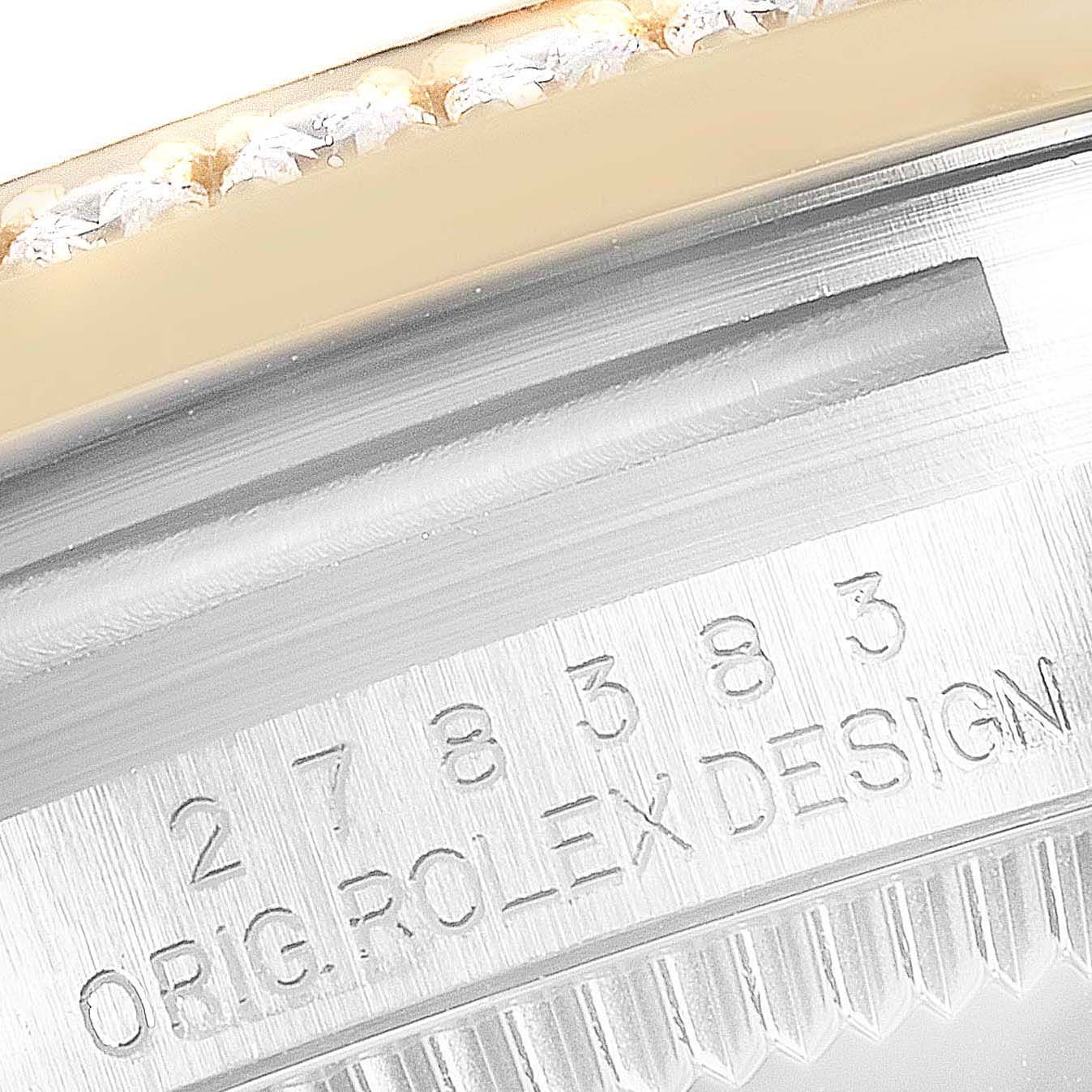 This image shows a close-up of the engraved serial number and original design marking on the bezel of a Mid-Size Rolex watch.