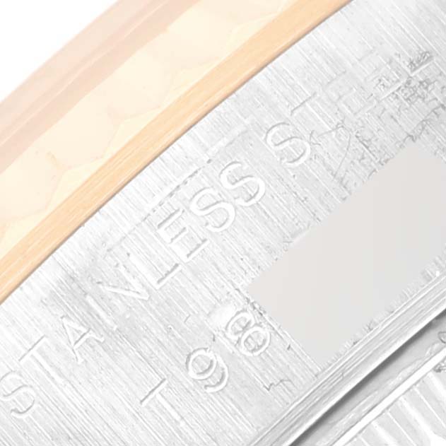 Close-up of the stainless steel and gold bezel of a Rolex Datejust 69173 Women's Steel and Gold (two tone) White Dial 69173 Women's Steel and Gold (two tone) White Dial watch, focusing on engravings and texture.