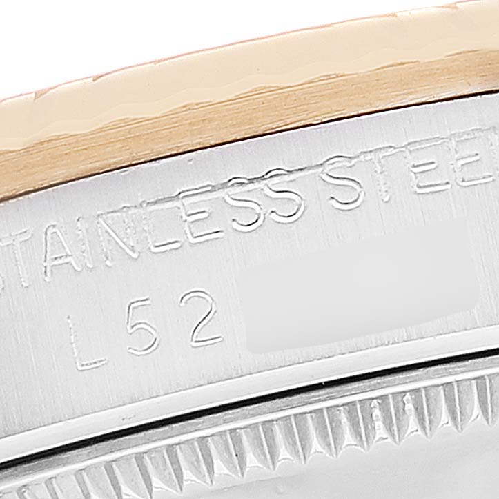 This is a close-up image of the case and bezel edge of a Rolex Mid-Size 68273 Women
s Steel and Gold (two tone) White Dial 68273 Women
s Steel and Gold (two tone) White Dial model, showing partial engravings.