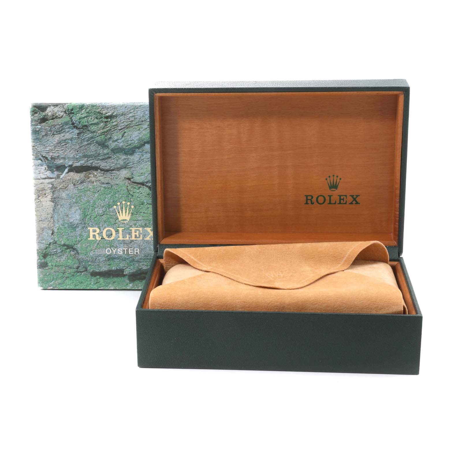 The image shows the Rolex packaging, including an open green box with wood interior and a tan suede pillow and cover inside.