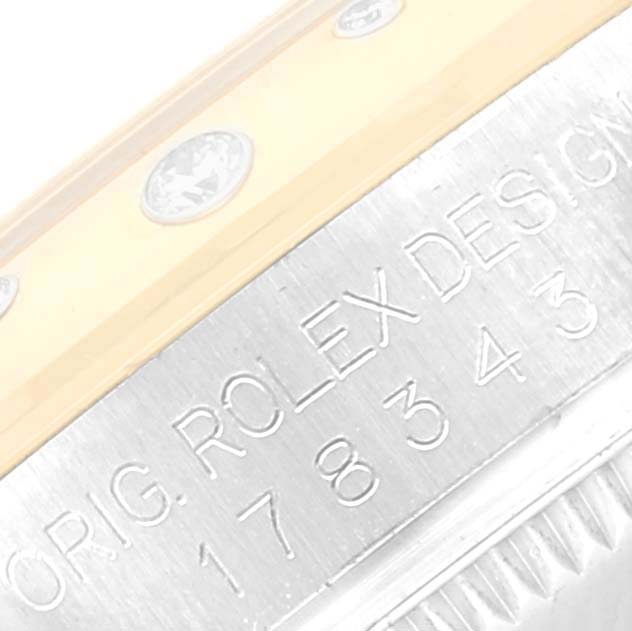 The image shows a close-up of the side of a Mid-Size Rolex watch, revealing part of the bezel and the engraved case.