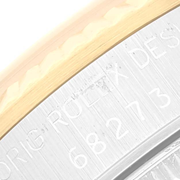 The image shows a close-up of the case back and engraved edge of a Mid-Size Rolex watch, featuring text detail.