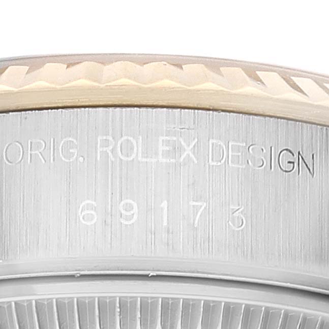 The image shows a close-up of the side view of the Rolex Datejust 69173 Women's Steel and Gold (two tone) Grey Dial 69173 Women's Steel and Gold (two tone) Grey Dial model, featuring the bezel and engraved design number.