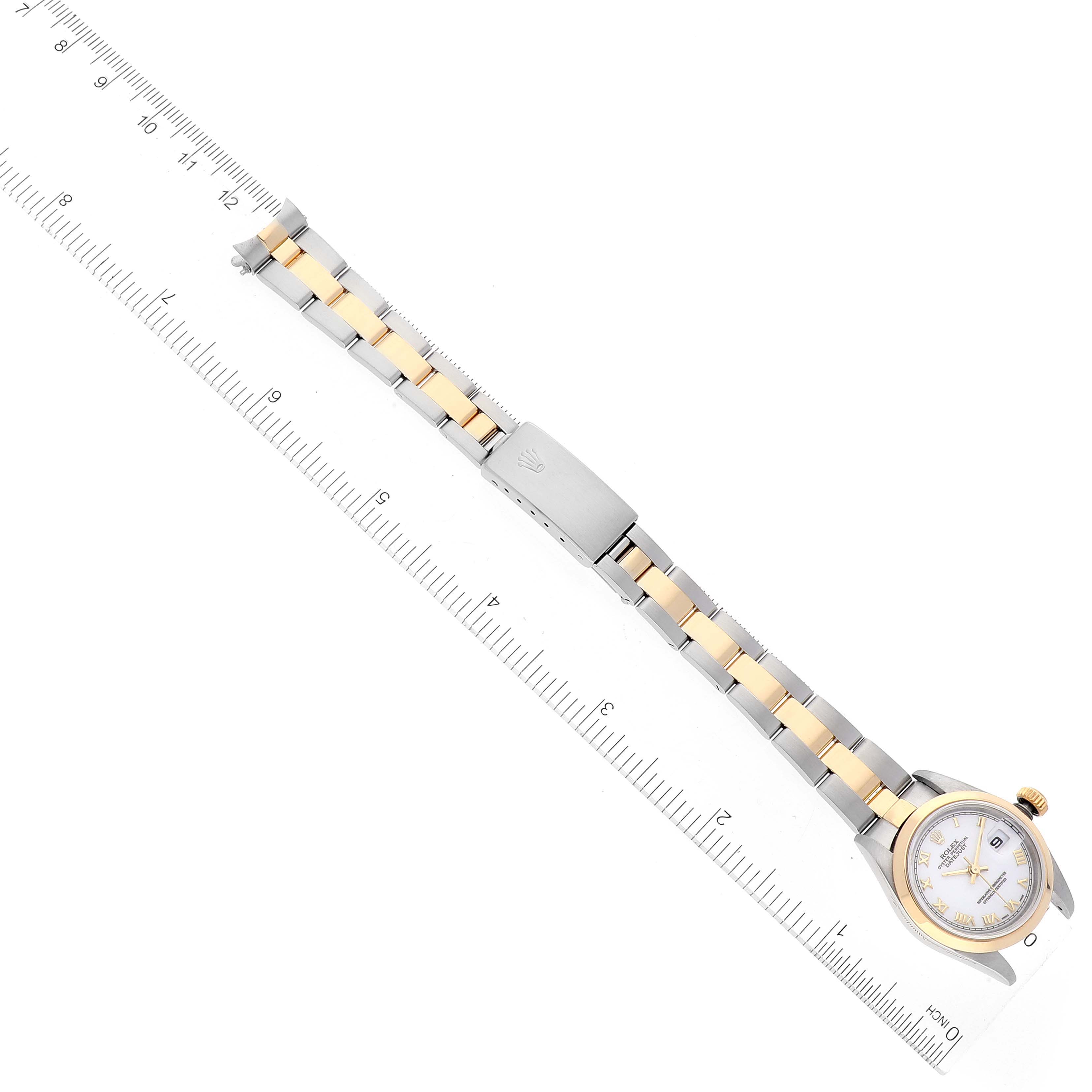 The image shows a Rolex Datejust 79163 Women's Steel and Gold (two tone) White Dial 79163 Women's Steel and Gold (two tone) White Dial watch laid flat with its two-tone bracelet and clasp, positioned alongside a ruler for scale.