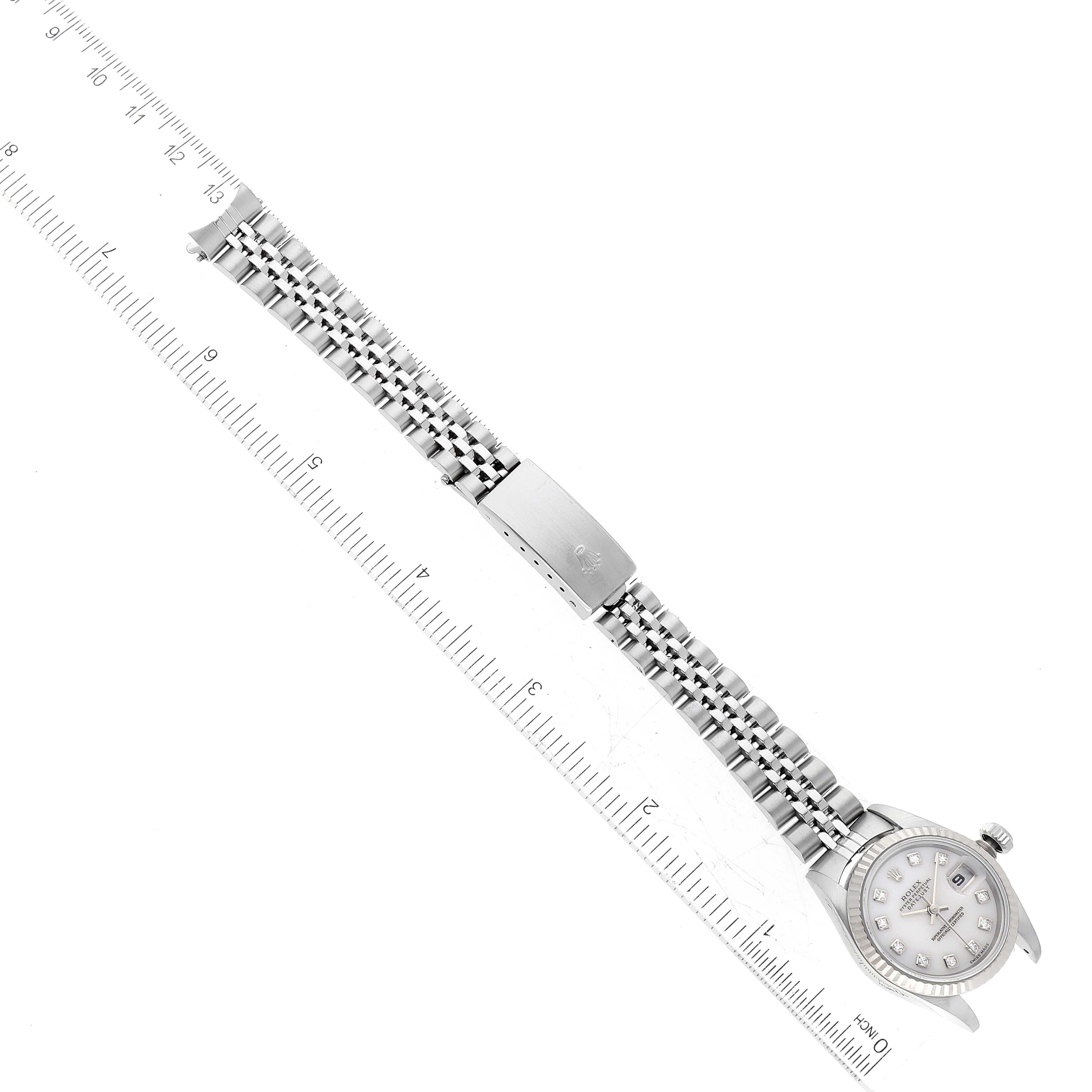 This image shows a top-down view of a Rolex Datejust 79174 Women's Stainless Steel Mother of Pearl Dial 79174 Women's Stainless Steel Mother of Pearl Dial watch, including the face, bracelet, and clasp, alongside a measuring ruler.