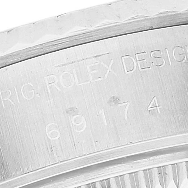 This zoomed-in shot of a Rolex Datejust 69174 Women's Stainless Steel Silver Dial 69174 Women's Stainless Steel Silver Dial watch shows the engraved serial and model numbers on the inner bezel.