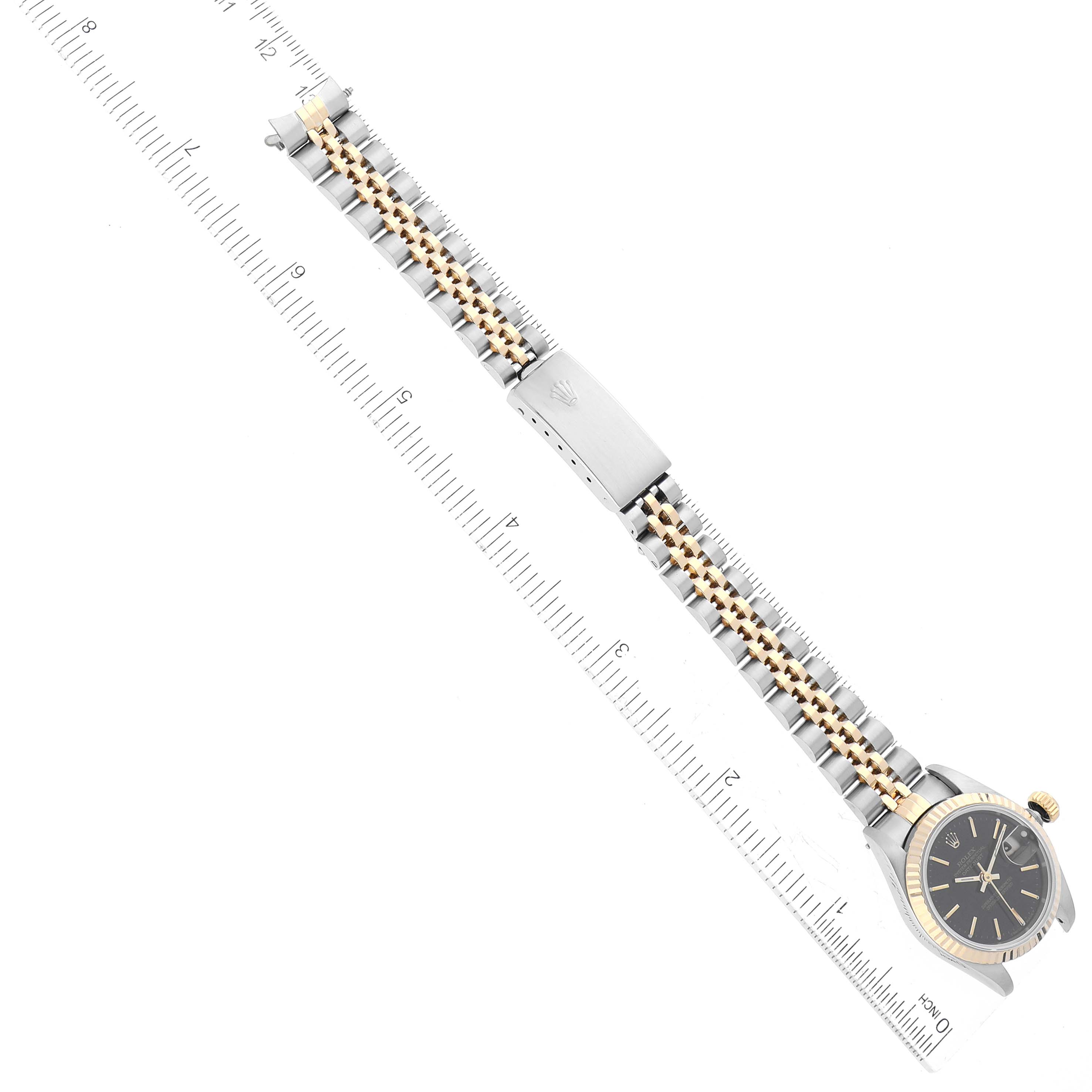 This image shows the Rolex Datejust 69173 Women's Steel and Gold (two tone) Black Dial 69173 Women's Steel and Gold (two tone) Black Dial watch at a top-down angle, featuring the watch's face, bracelet, and clasp, alongside a ruler.