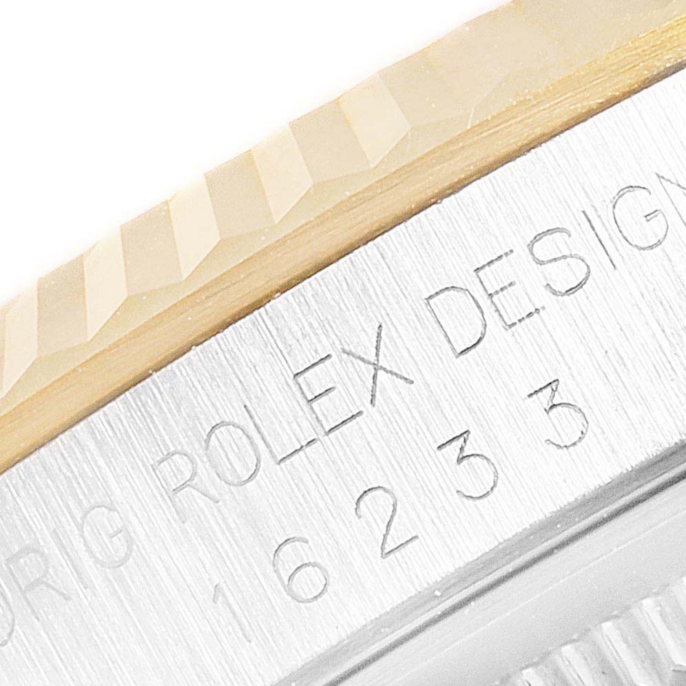 This close-up image of a Rolex Datejust 16233 Men
s Steel and Gold (two tone) Grey Dial 16233 Men
s Steel and Gold (two tone) Grey Dial watch shows the engraved side, displaying "ROLEX DESIGN" and part of the reference number.