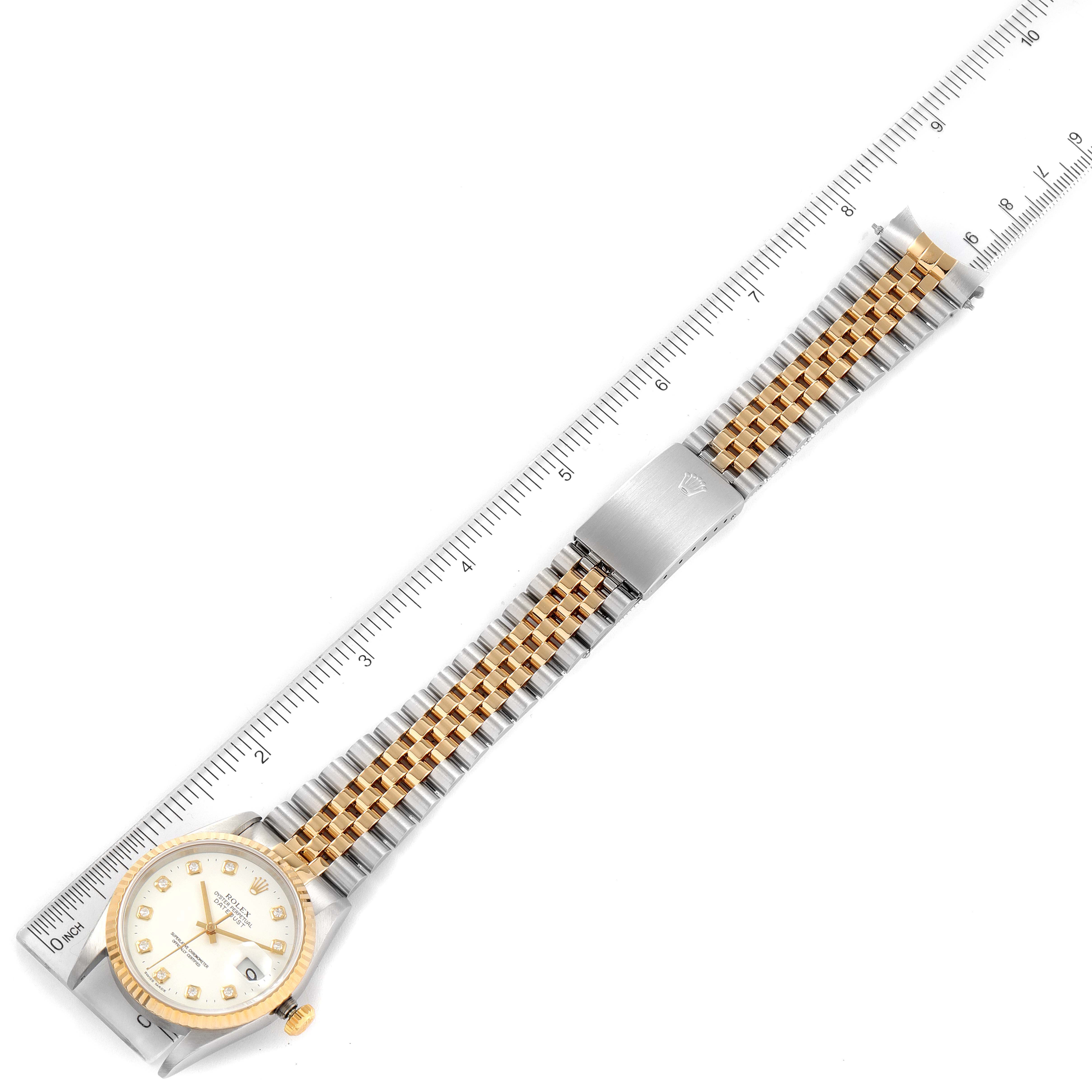 The image shows a Rolex Datejust 16233 Men's Steel and Gold (two tone) White Dial 16233 Men's Steel and Gold (two tone) White Dial watch laid flat, with the dial, jubilee bracelet, and clasp visible next to a ruler.