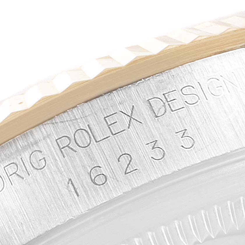 This image shows a close-up of the serial number and the fluted bezel of a Rolex Datejust 16233 Men's Steel and Gold (two tone) White Dial 16233 Men's Steel and Gold (two tone) White Dial watch.
