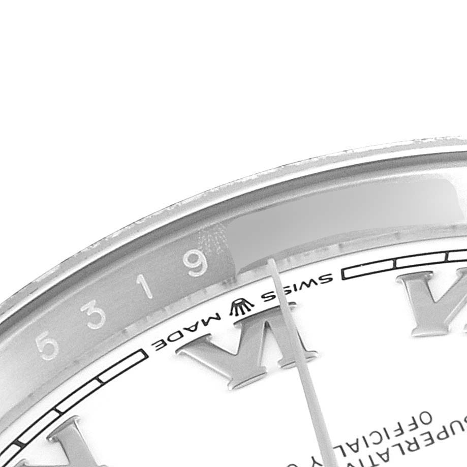 This image shows a close-up of the Datejust Rolex watch, focusing on part of the dial, the brand logo, Roman numeral, and some minute markers.