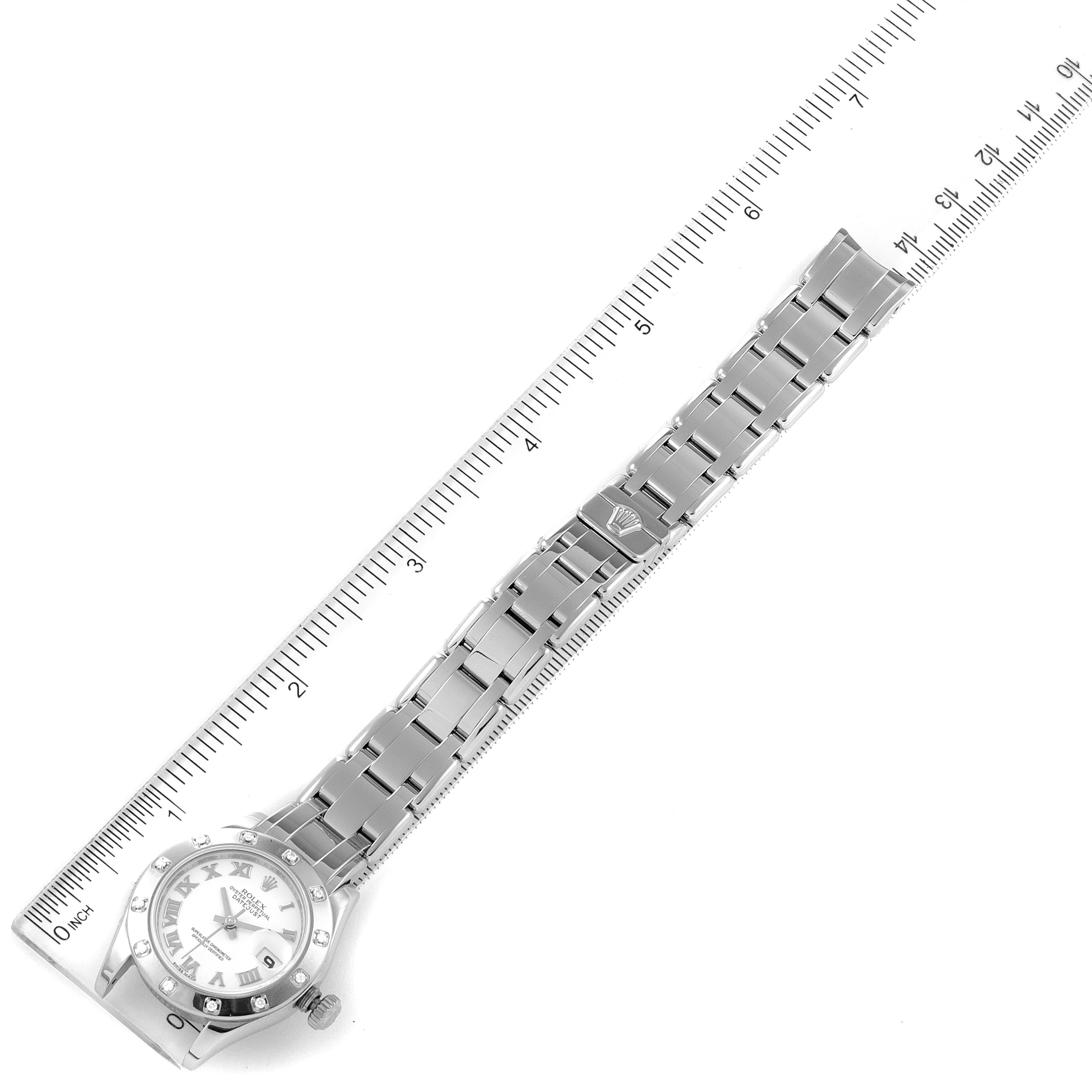 The Rolex Pearlmaster 80319 Women's White Gold White Dial 80319 Women's White Gold White Dial watch is photographed from above, displaying the face and entire band, with a ruler alongside for scale.