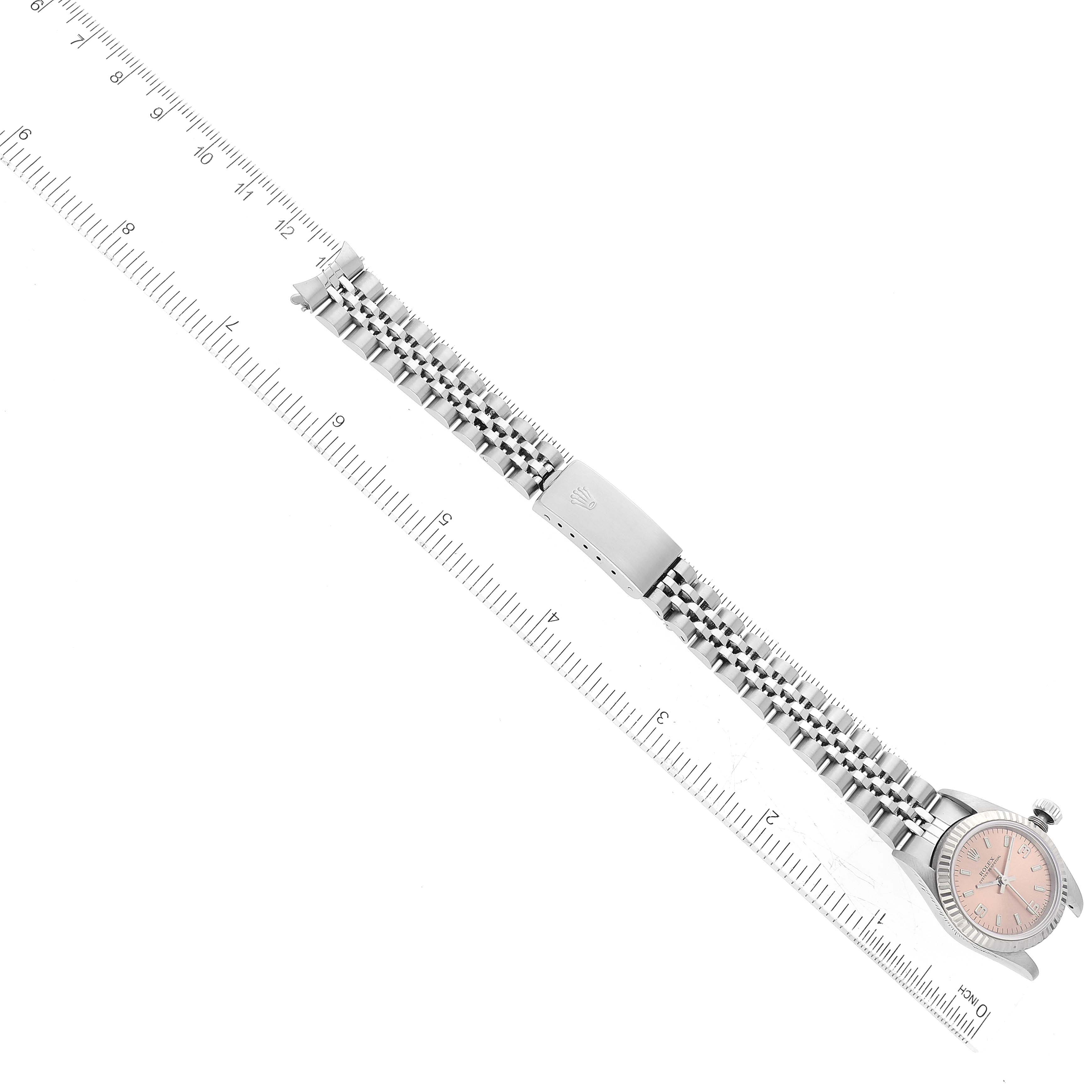The image shows a top-down view of a Rolex Oyster Perpetual 67194 Women's Stainless Steel Orange Dial 67194 Women's Stainless Steel Orange Dial watch, including the face, bracelet, and clasp.