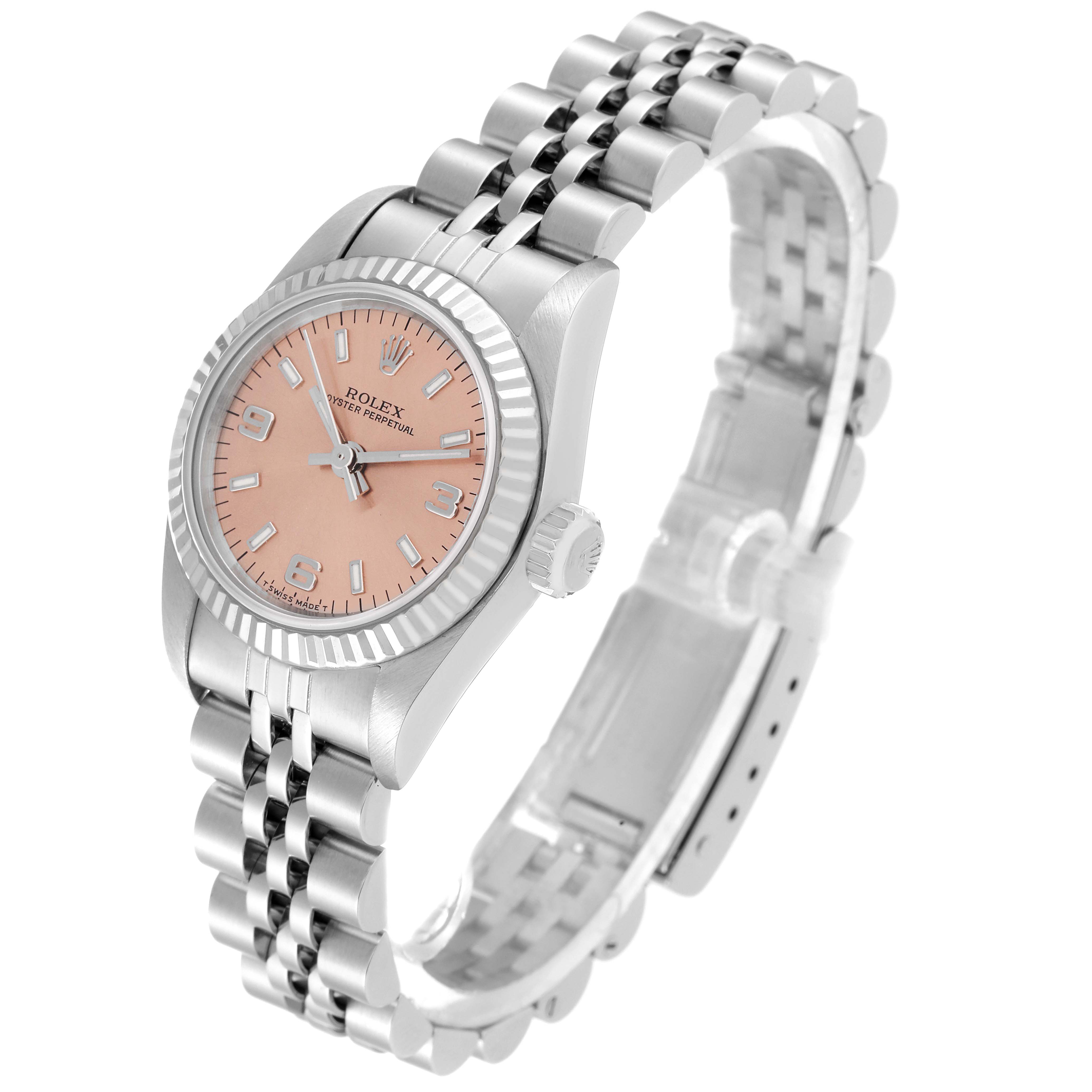 The image shows a side angle of the Rolex Oyster Perpetual 67194 Women's Stainless Steel Orange Dial 67194 Women's Stainless Steel Orange Dial watch, highlighting its pink dial, fluted bezel, and jubilee bracelet.