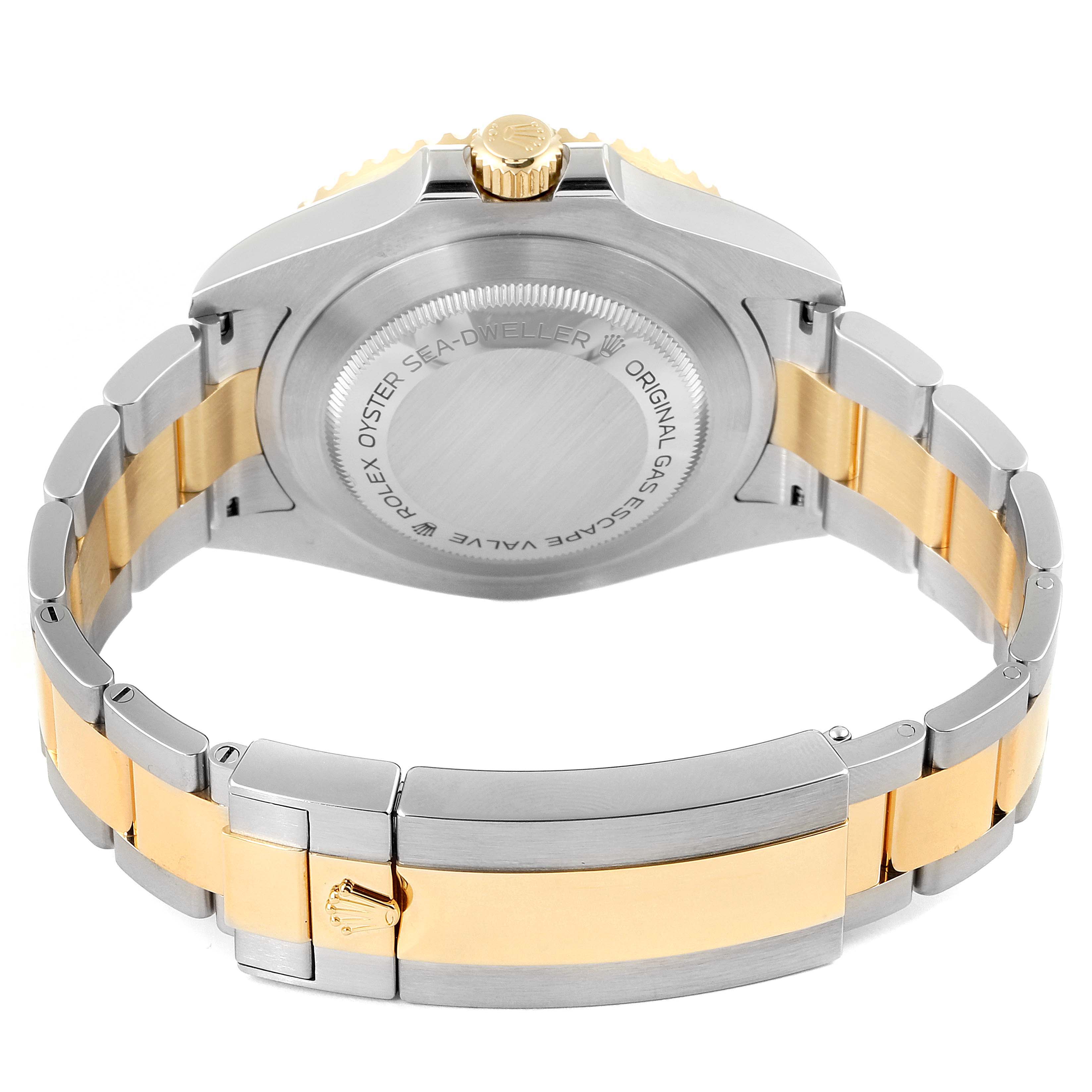 The image shows the back view of a Rolex Sea-Dweller 126603 Men
s Steel and Gold (two tone) Black Dial 126603 Men
s Steel and Gold (two tone) Black Dial watch, highlighting its case back, crown, and two-tone metal bracelet.