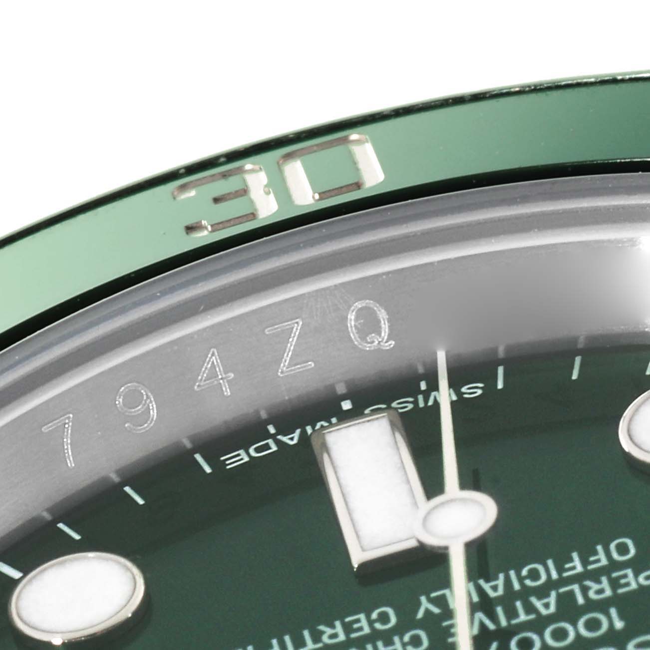 This close-up of a Rolex Submariner 116610LV Men's Stainless Steel Green Dial 116610LV Men's Stainless Steel Green Dial watch shows the bezel, part of the dial, and the engraving on the rehaut.