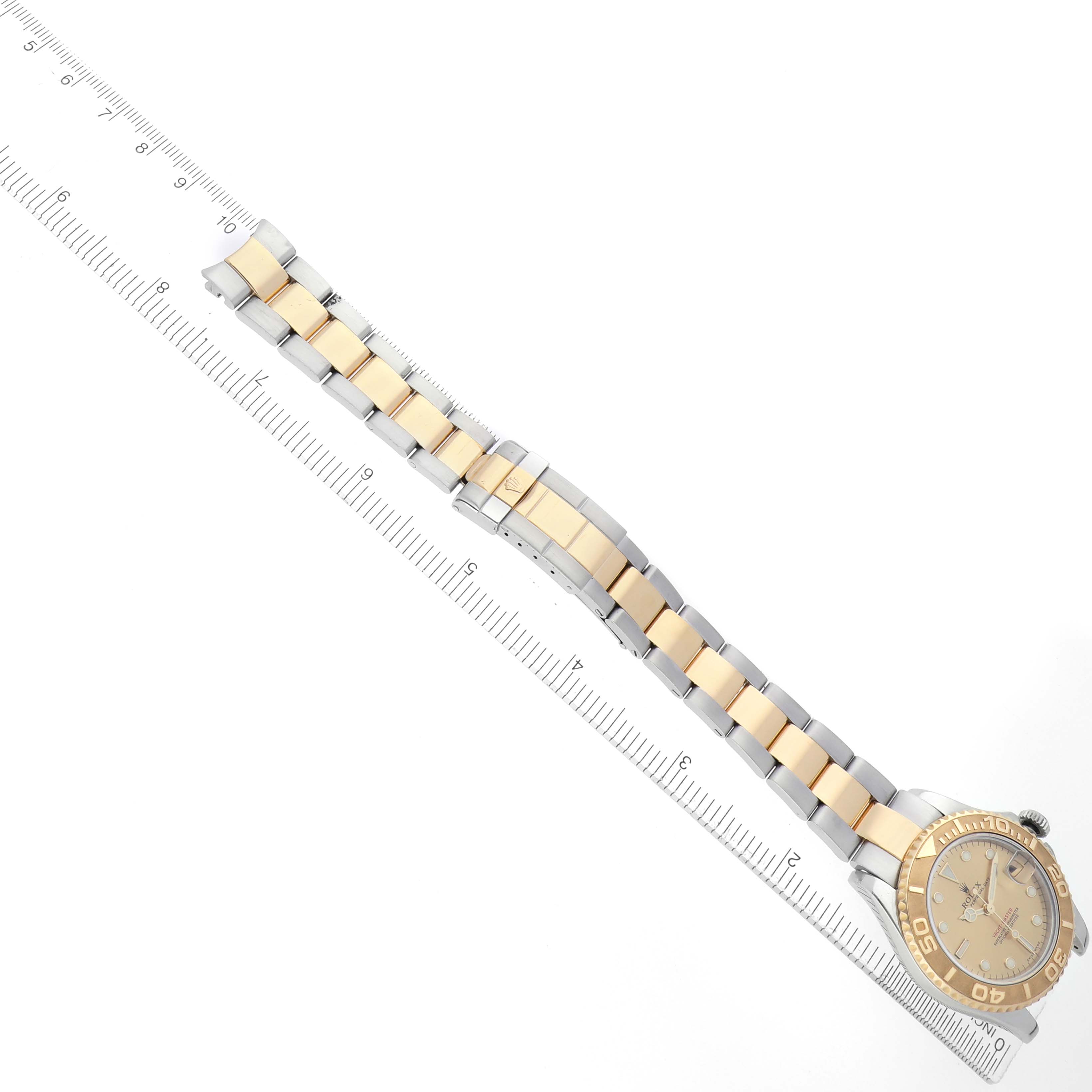 The image shows a Rolex Yacht-Master 168623 Men's Steel and Gold (two tone) Champagne Dial watch at an angle displaying the bracelet, case, bezel, and dial alongside a measuring ruler.