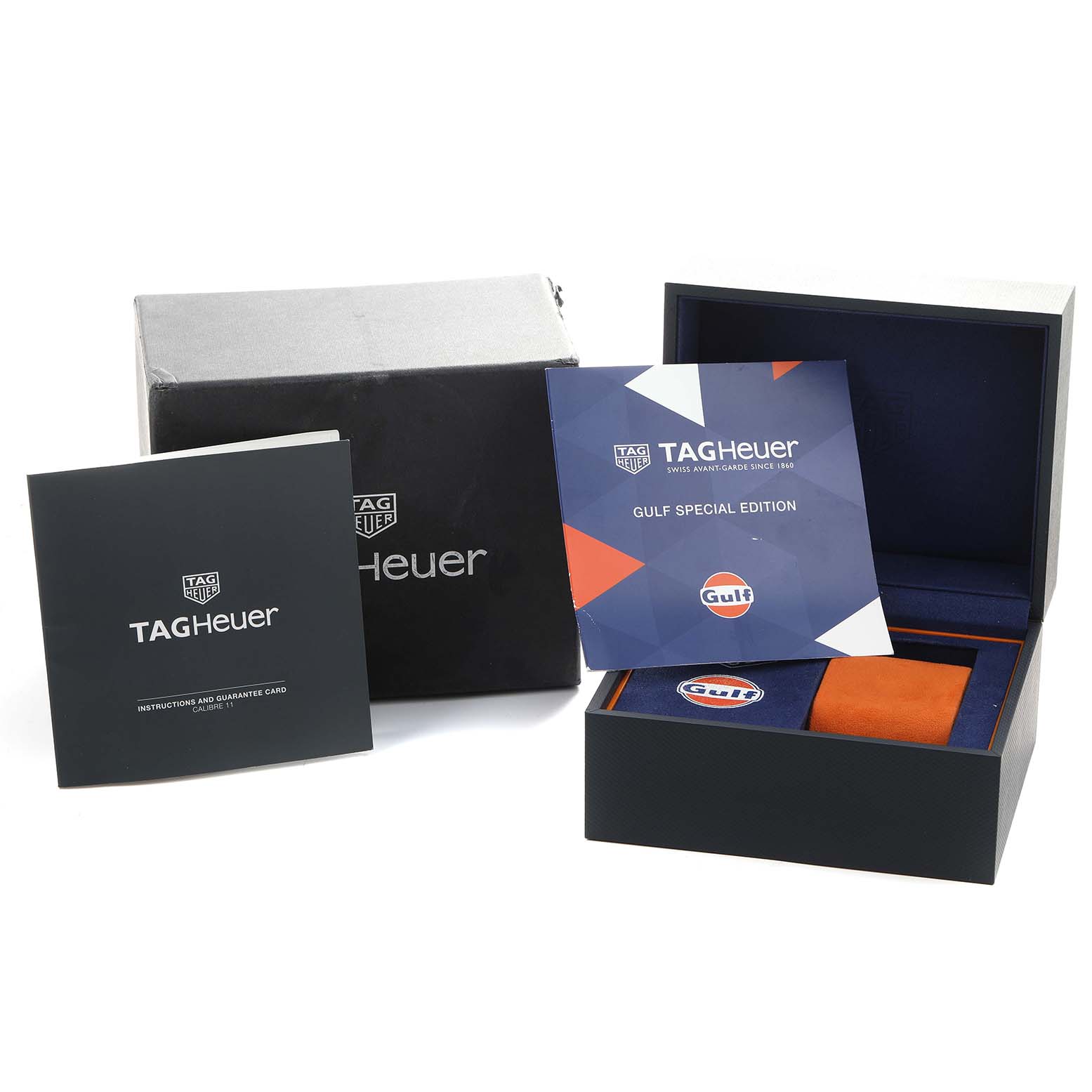 The image shows the packaging and accessories for a Tag Heuer Monaco CAW211R Men's Stainless Steel Blue Dial watch, including the box and instruction booklet.