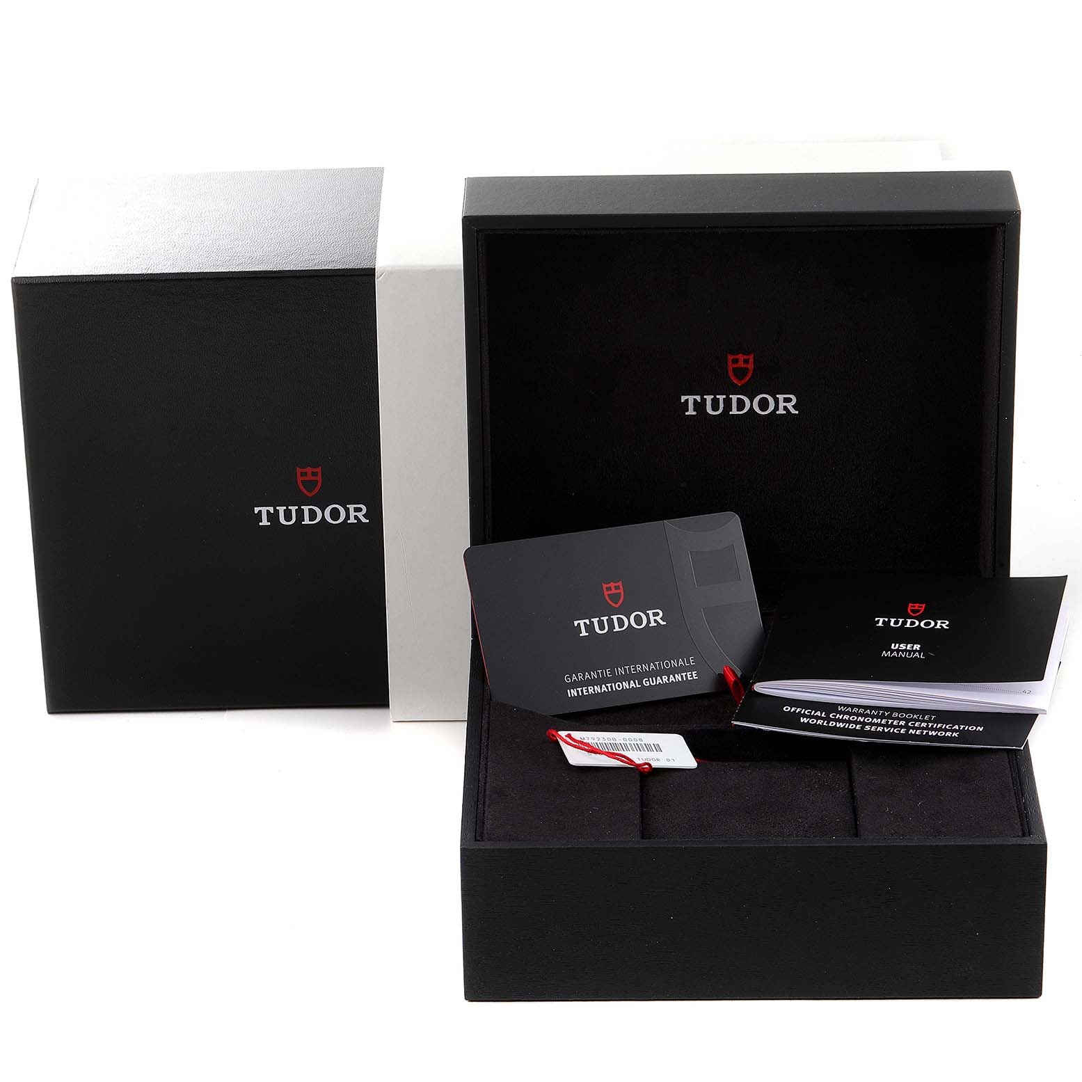 The image shows the packaging of the Tudor Heritage Black Bay 79230B Men
s Stainless Steel Black Dial 79230B Men
s Stainless Steel Black Dial watch, including the box, warranty card, and user manual.