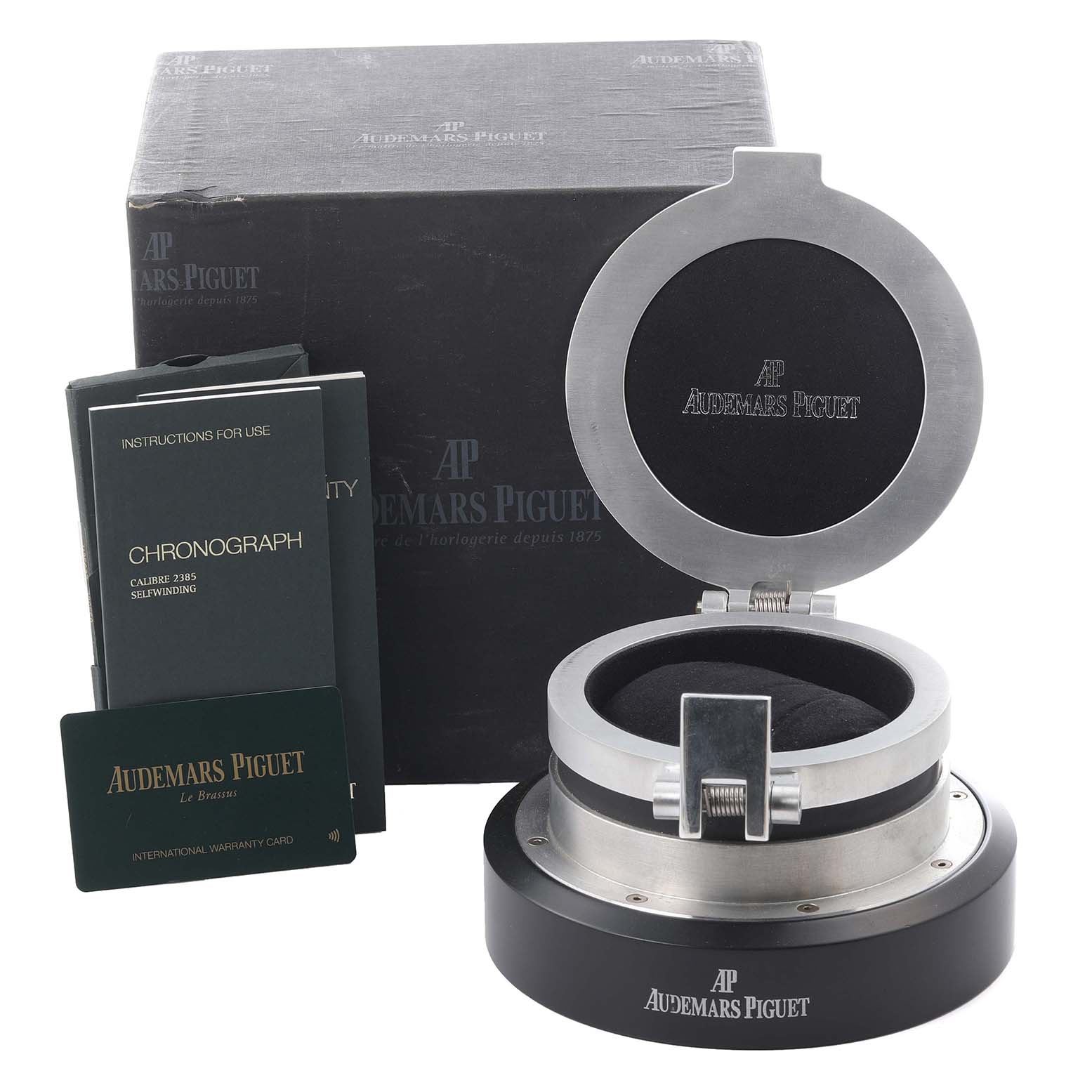 The image shows an Audemars Piguet Jules 26558TI.OO.D080VE.01 Men
s Titanium Grey Dial 26558TI.OO.D080VE.01 Men
s Titanium Grey Dial watch box, open, with manuals and warranty card beside it.