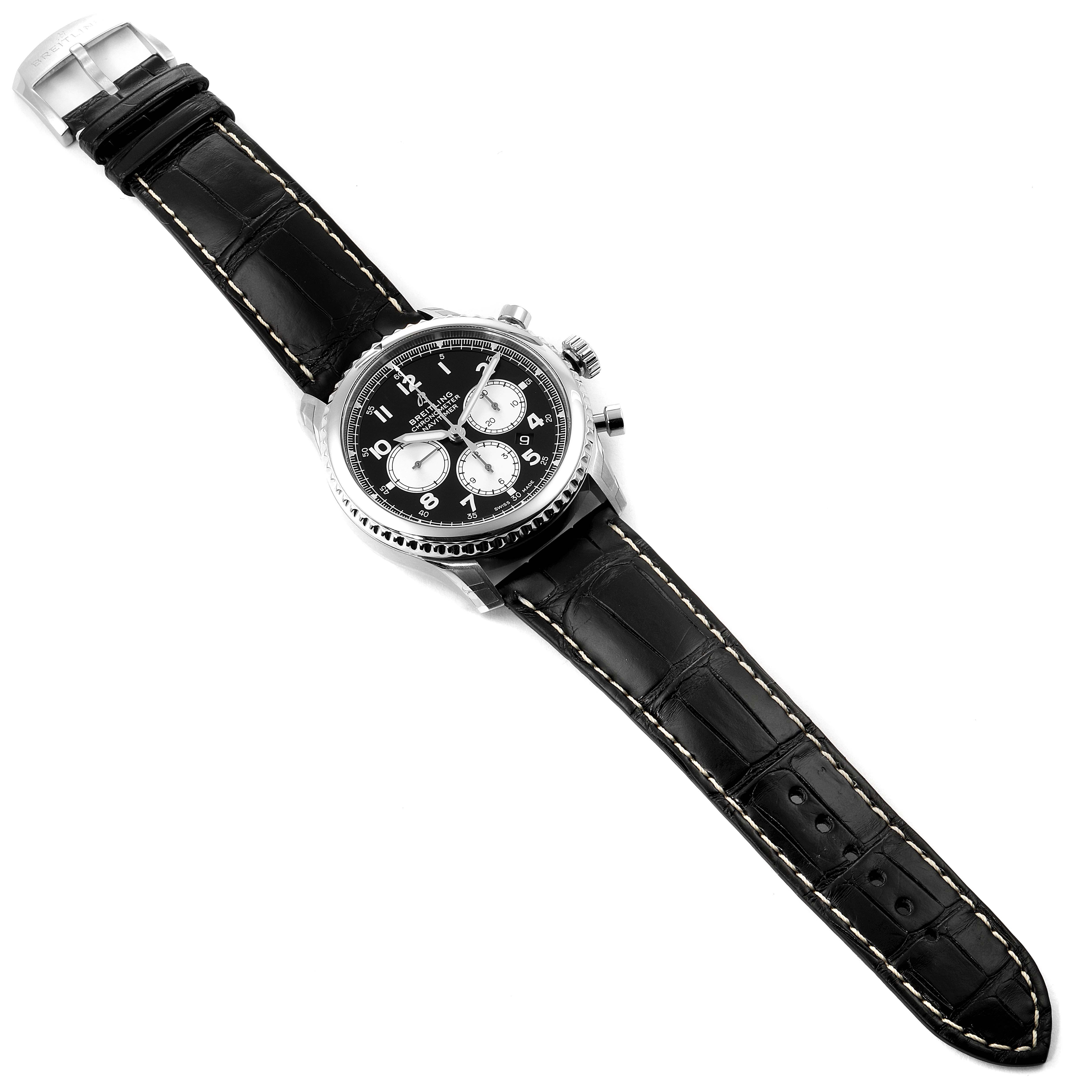 The image shows a top view of a Breitling Navitimer watch with a black leather strap and a black dial with silver subdials.