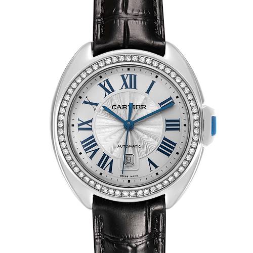 The Cartier Clé watch is shown from a top-down angle, highlighting its dial, Roman numerals, diamond bezel, and leather strap.