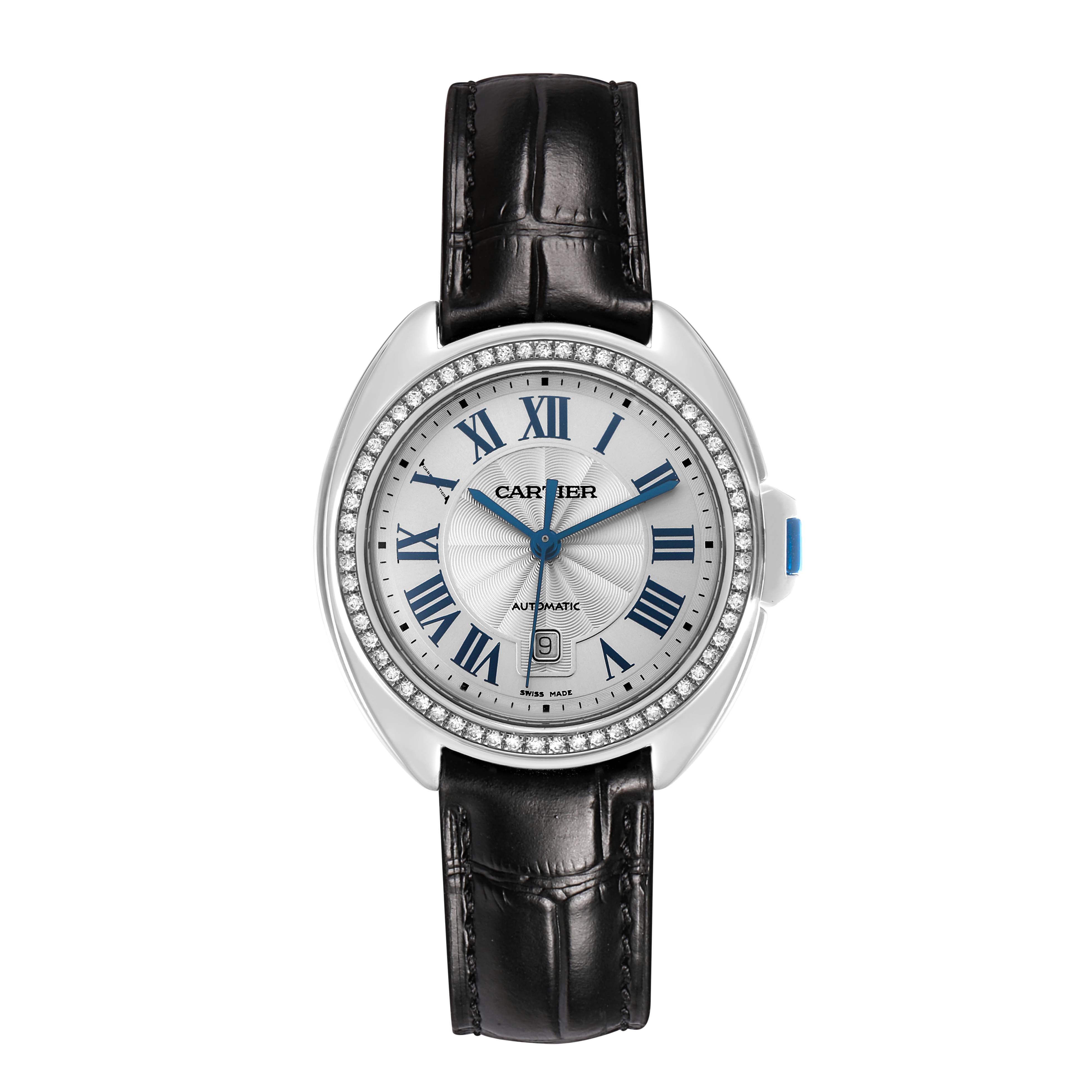 The image shows a Cartier Clé watch from the front, highlighting its Roman numeral dial, blue hands, diamond bezel, and black leather strap.