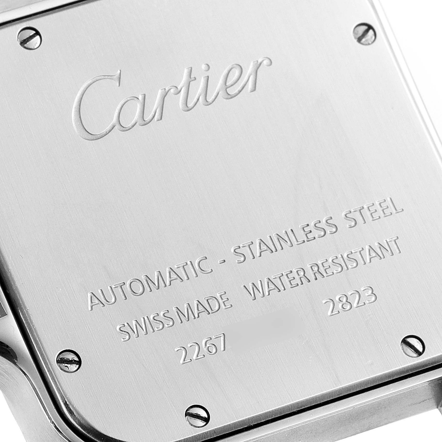 This image shows a close-up of the back case of a Santos model watch by Cartier, highlighting the engraved details and screws.