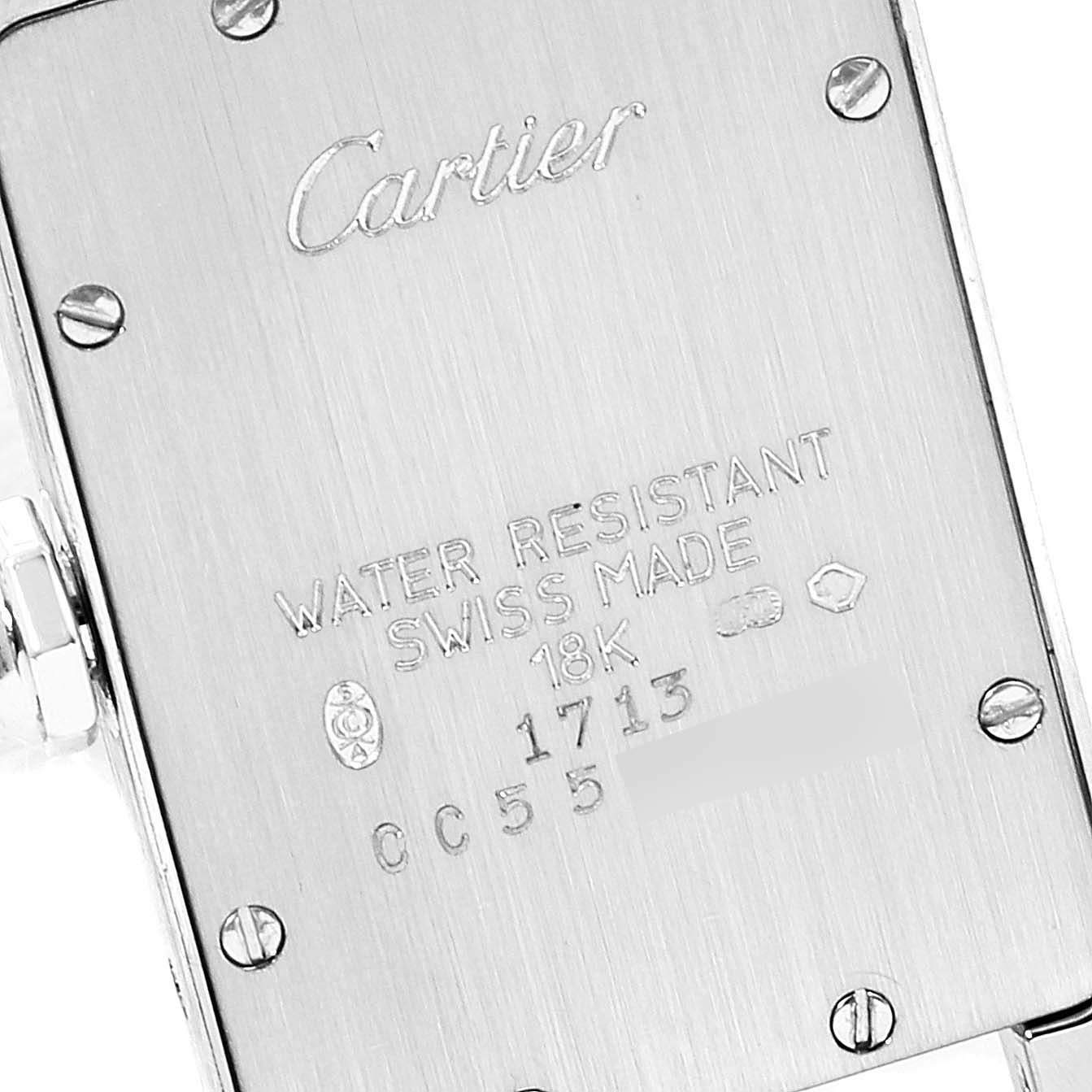 This image shows the back case of a Cartier Tank Americaine W26019L1  Women's White Gold Silver Dial W26019L1  Women's White Gold Silver Dial watch with engraved details and screws visible.
